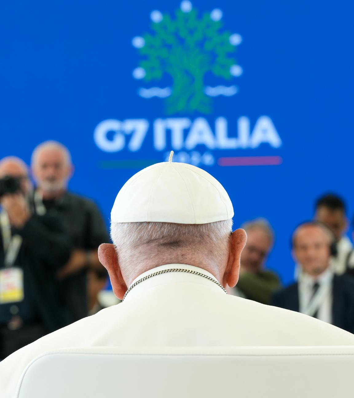 Papst Franziskus, von hinten fotografiert, im Hintergrund das Logo des G7-Gipfels, in Bari, Italien.