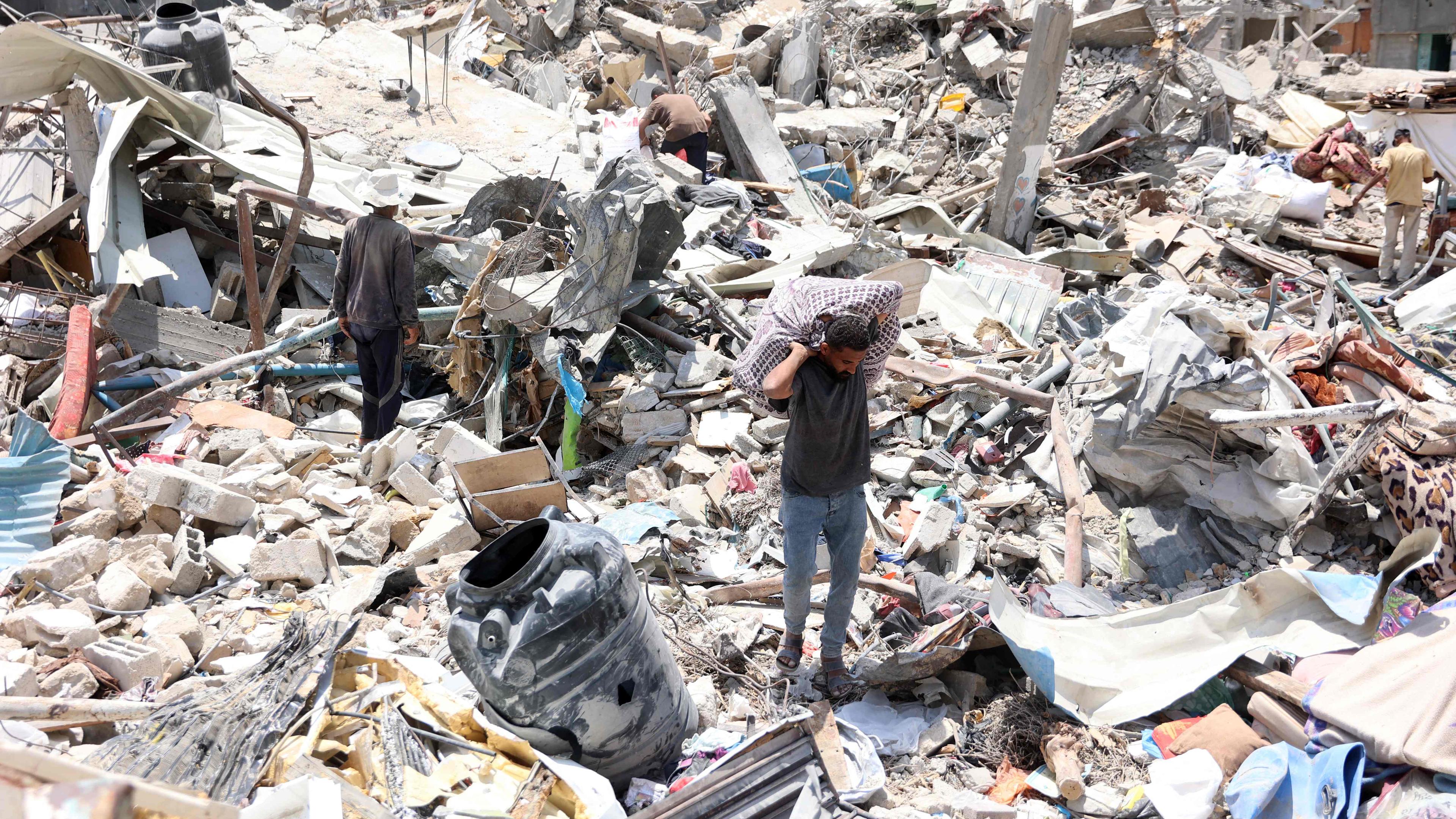 Ein Palästinenser trägt einen Sack mit Waren, die er am 3. Juni 2024 unter den Trümmern zerstörter Gebäude im Flüchtlingslager Jabalia im nördlichen Gazastreifen geborgen hat, inmitten des anhaltenden Konflikts zwischen Israel und der militanten palästinensischen Hamas-Gruppe.