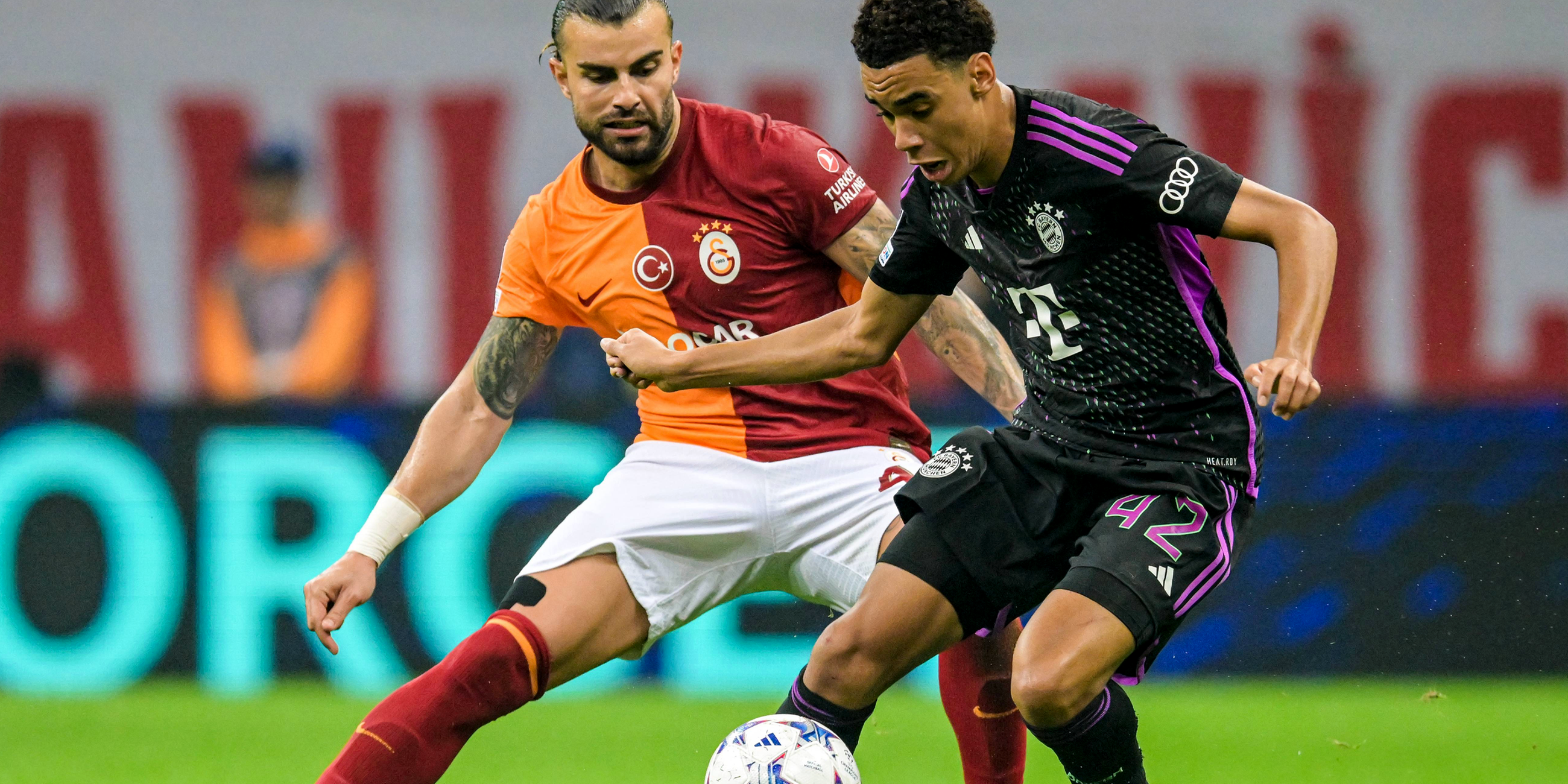 Abdulkerim Bardakci von Galatasaray und Jamal Musiala vom FC Bayern München kämpfen um den Ball.