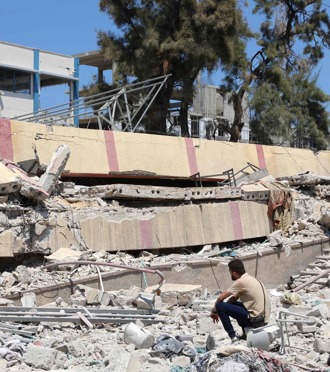 Ein Mann sitzt in den Trümmern eines zerstörten Gebäudes im Gazastreifen.