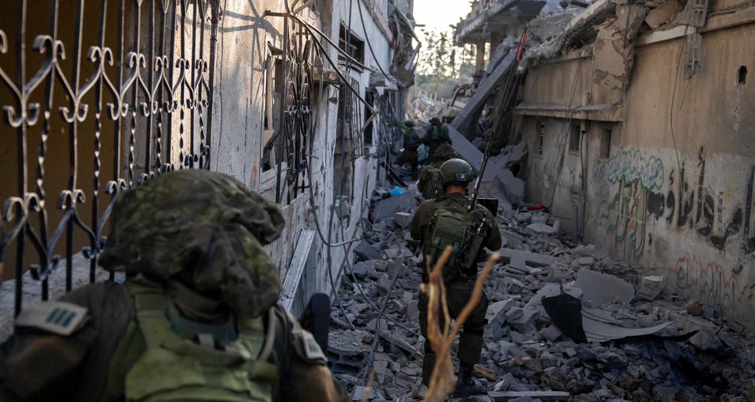 Israelische Soldaten laufen durch Trümmer