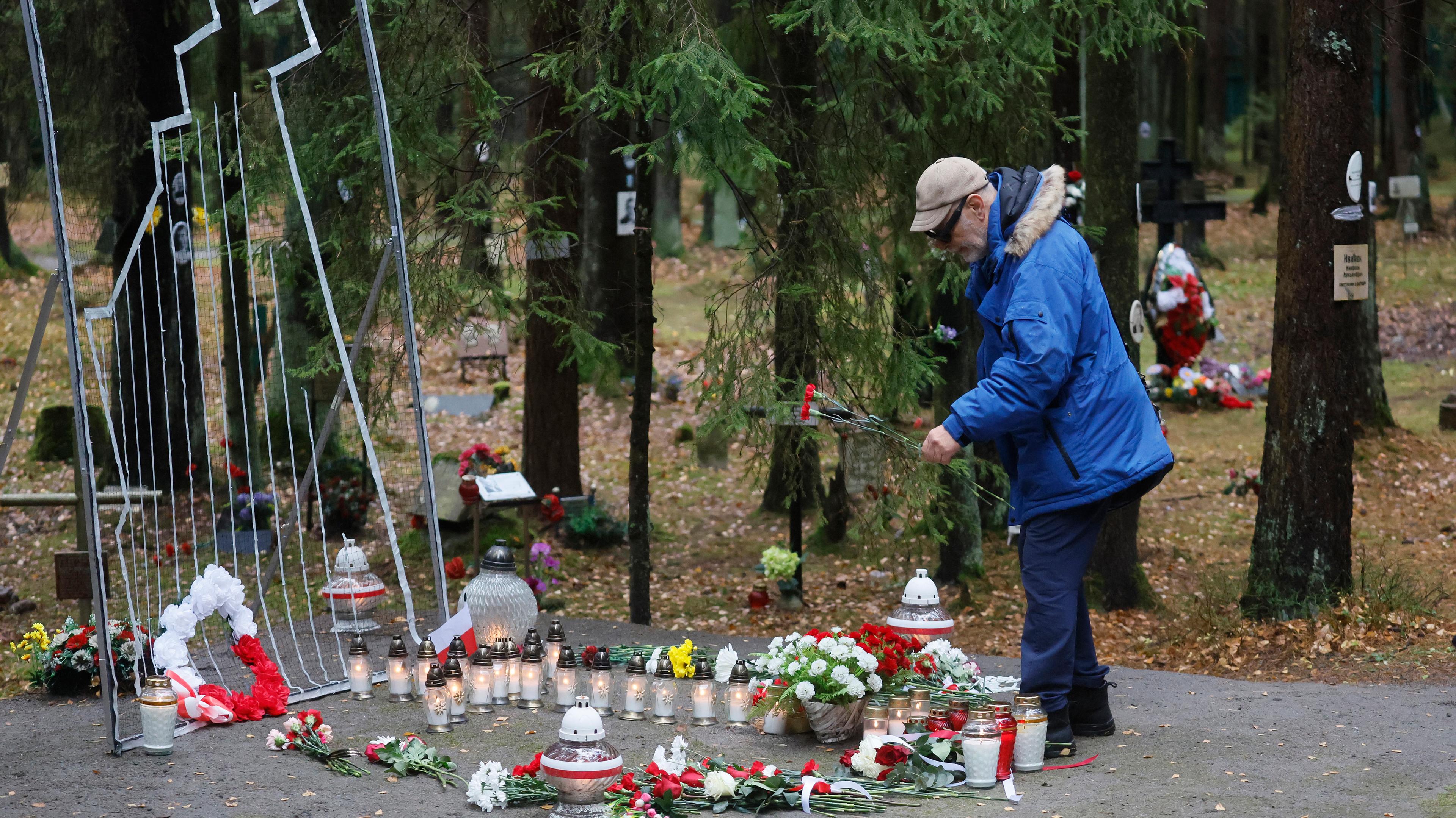 Ein Mann legt Blumen an einem Denkmal nieder, dass den Opfern der politischen Verfolgung des Stalin-Regimes gewidmet ist.