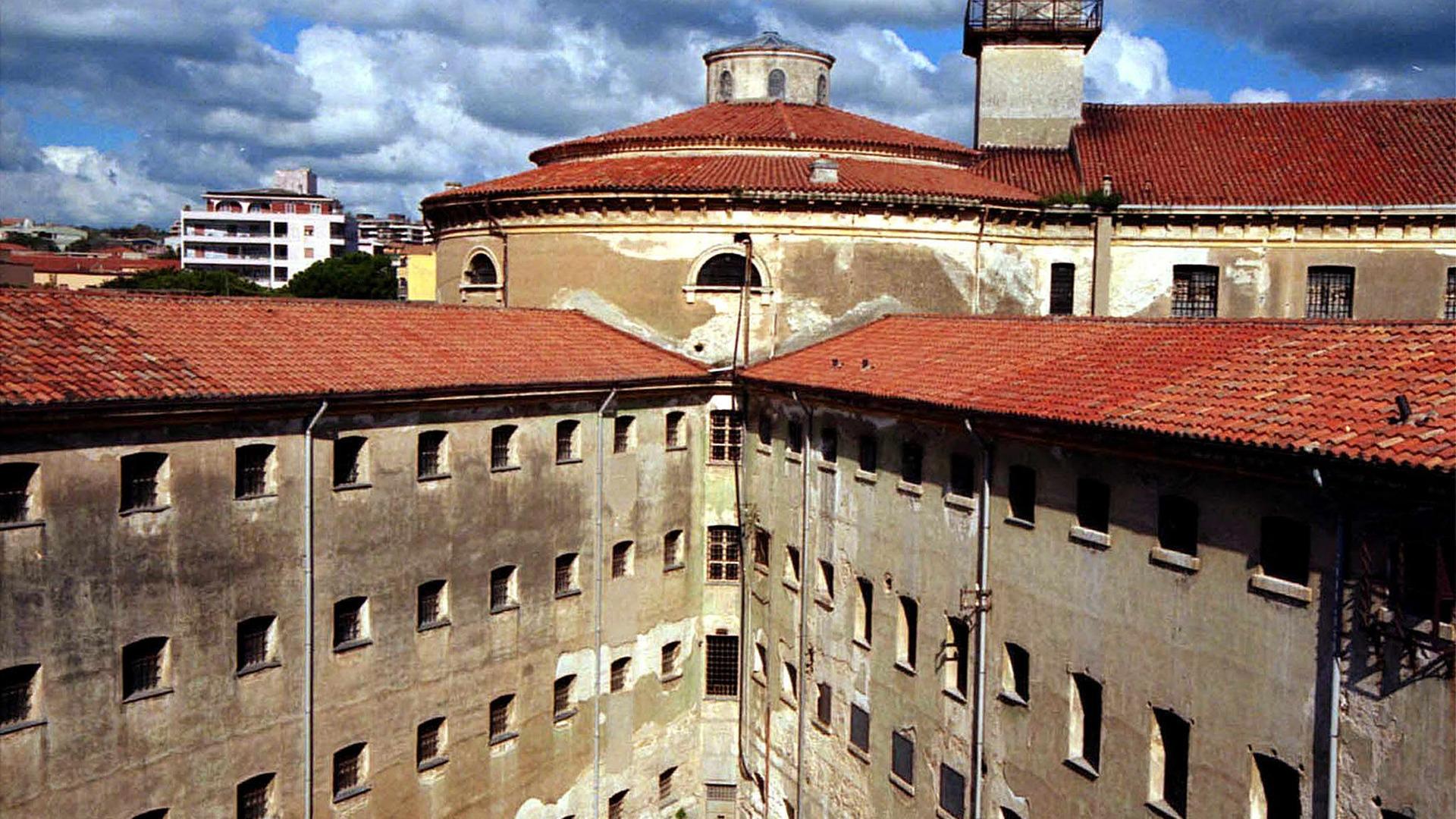 Ein Gefängniskomplex in Italien. Es ist ein verwinkeltes braunes Gebäude.