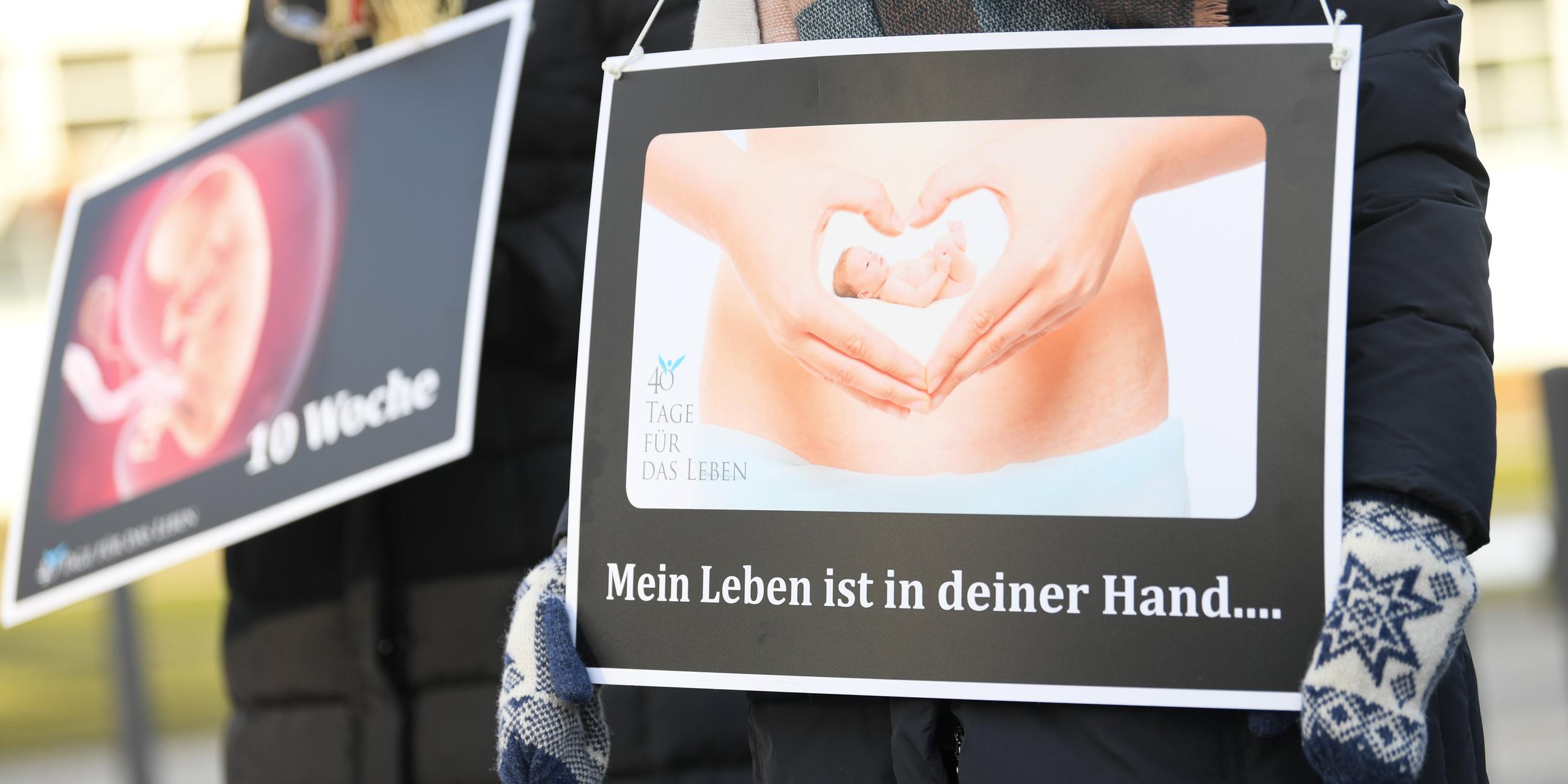 Mit Plakaten mit der Aufschrift "Mein Leben ist in deiner Hand..." und dem Bild