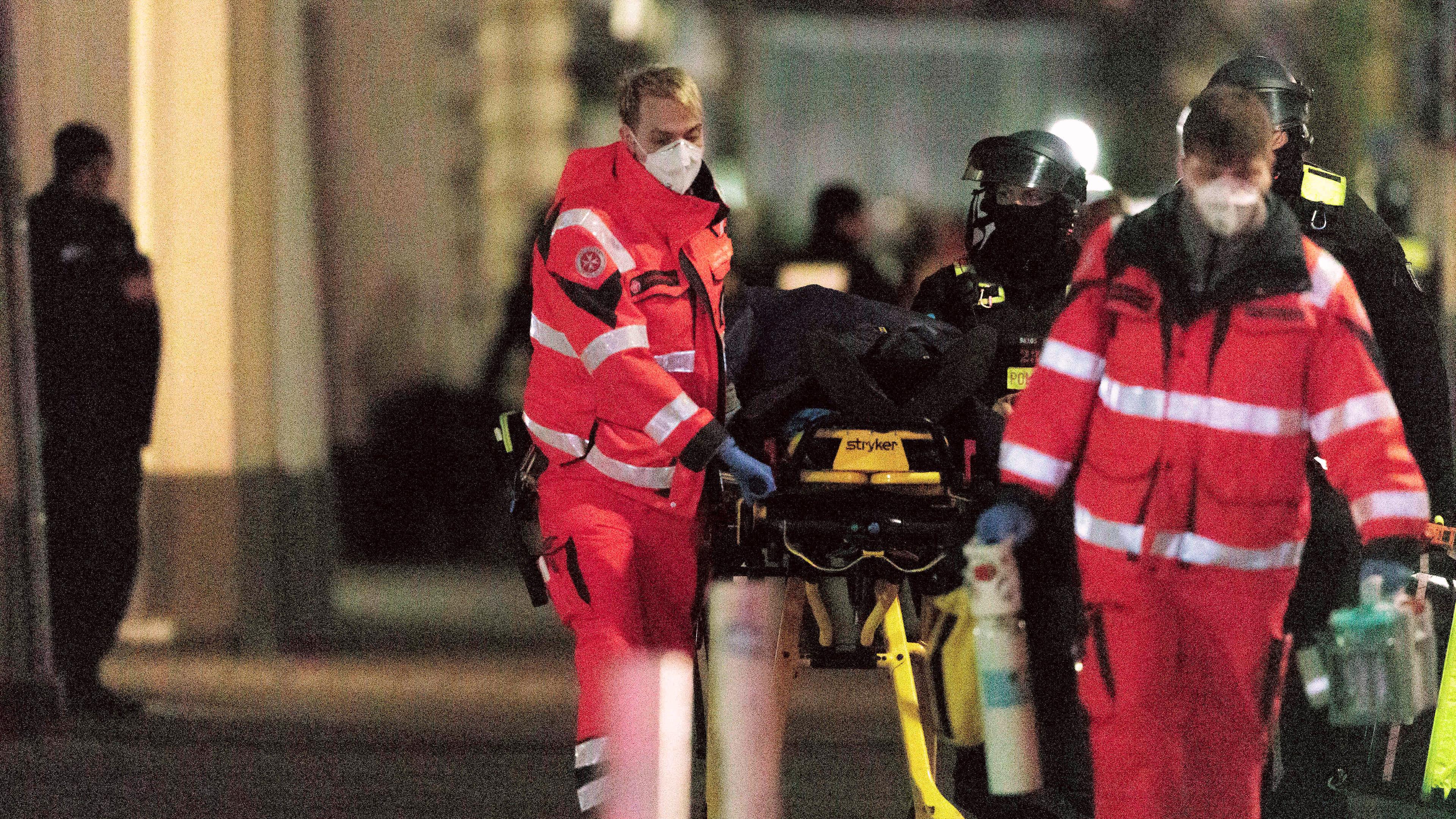Rettungssanitäter und Polizisten schieben eine Trage mit der unverletzten Geisel zu einem Krankenwagen nach dem Sturm eines Geschäftes an der Keithstraße durch die Polizei in Berlin-Schöneberg, aufgenommen am 25.04.2023