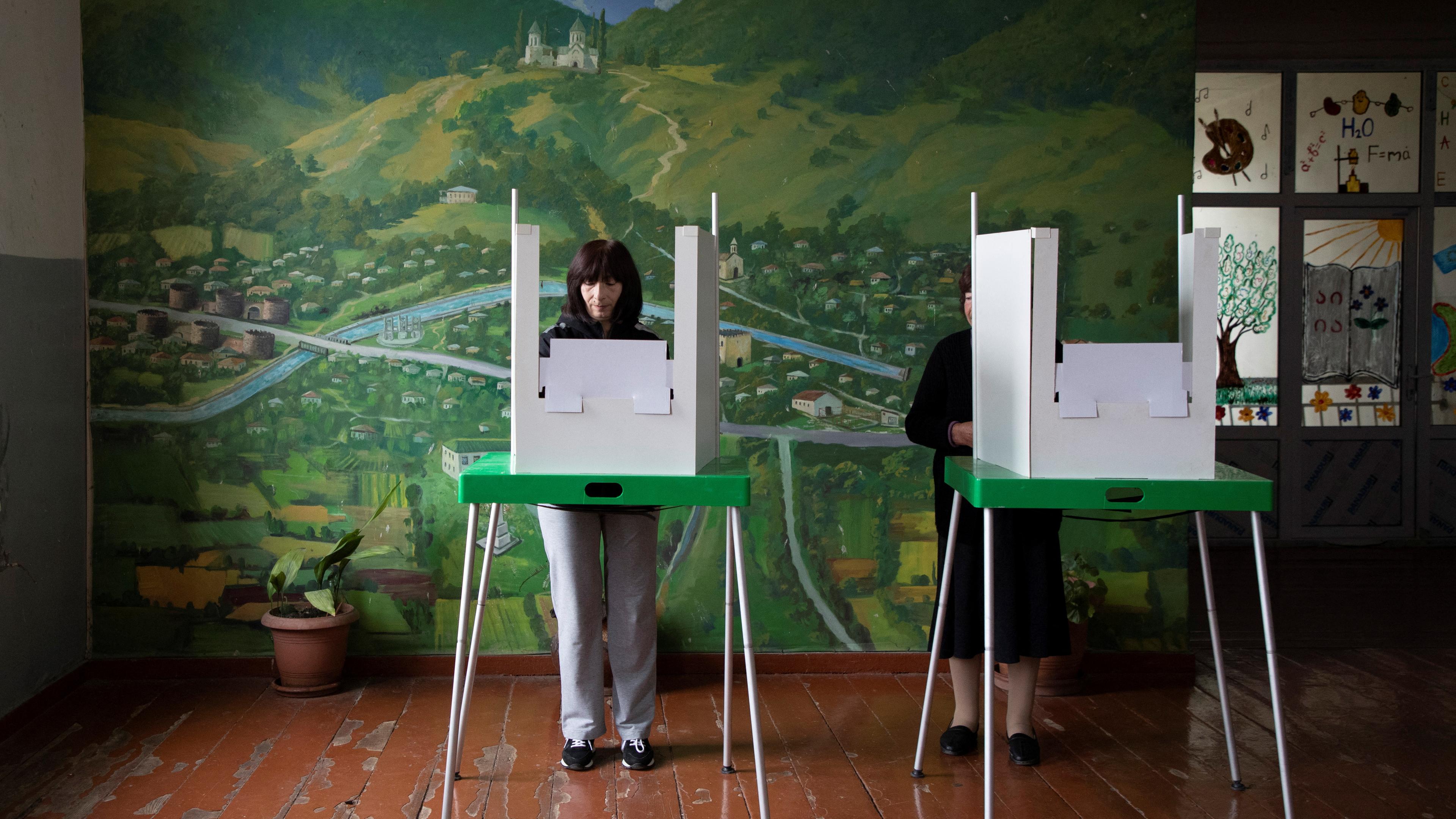 Wähler füllen ihre Stimmzettel in einem Wahllokal während der Parlamentswahlen im Dorf Atskuri in der Region Kachetien, Georgien, am 26. Oktober 2024 aus.