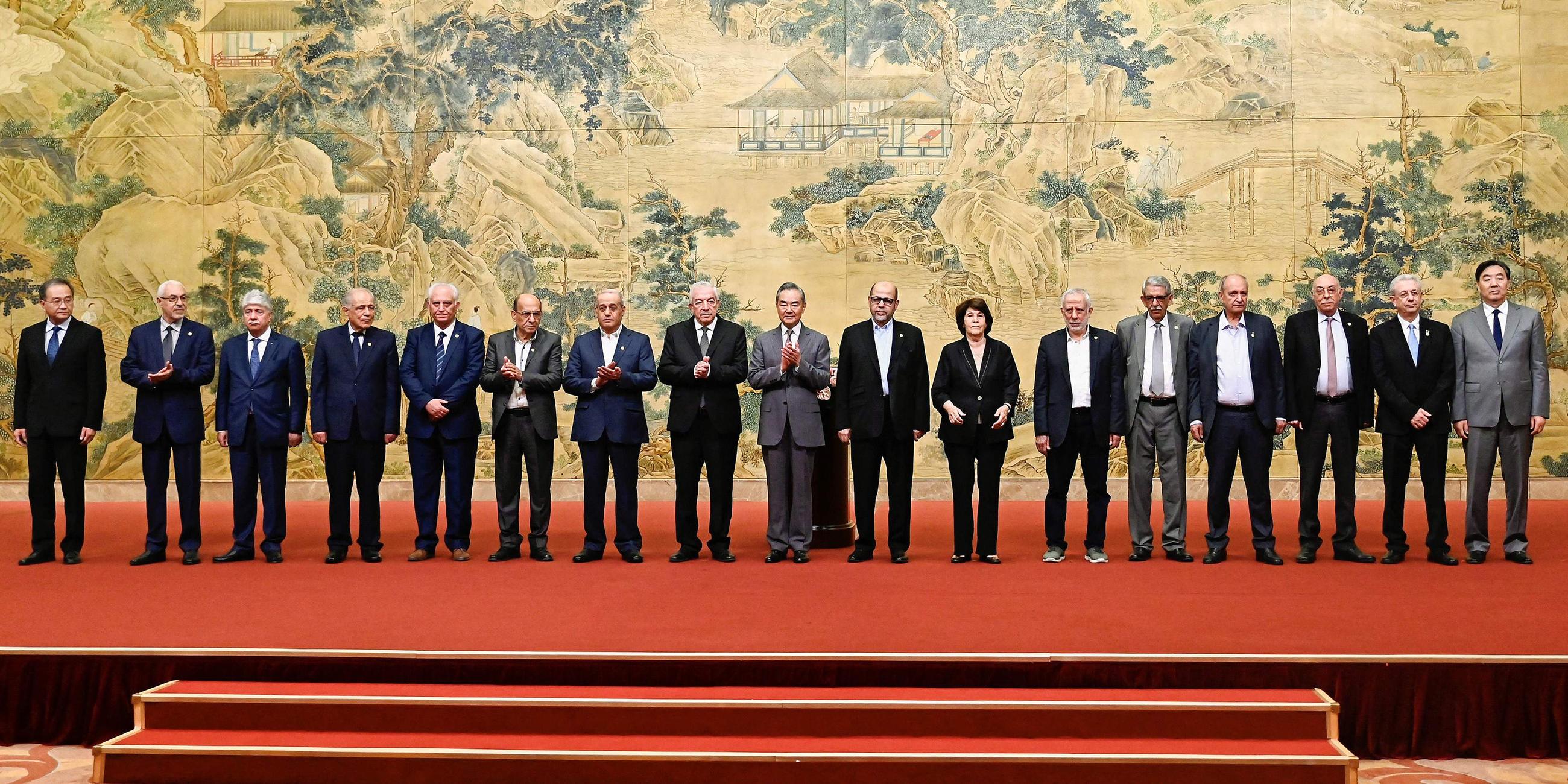 hinas Außenminister Wang Yi (Mitte) posiert für ein Gruppenbild mit Mitgliedern der palästinensischen Fraktionen während der Unterzeichnung der „Pekinger Erklärung“ im Diaoyutai State Guesthouse in Peking (China) am 23.07.2024)
