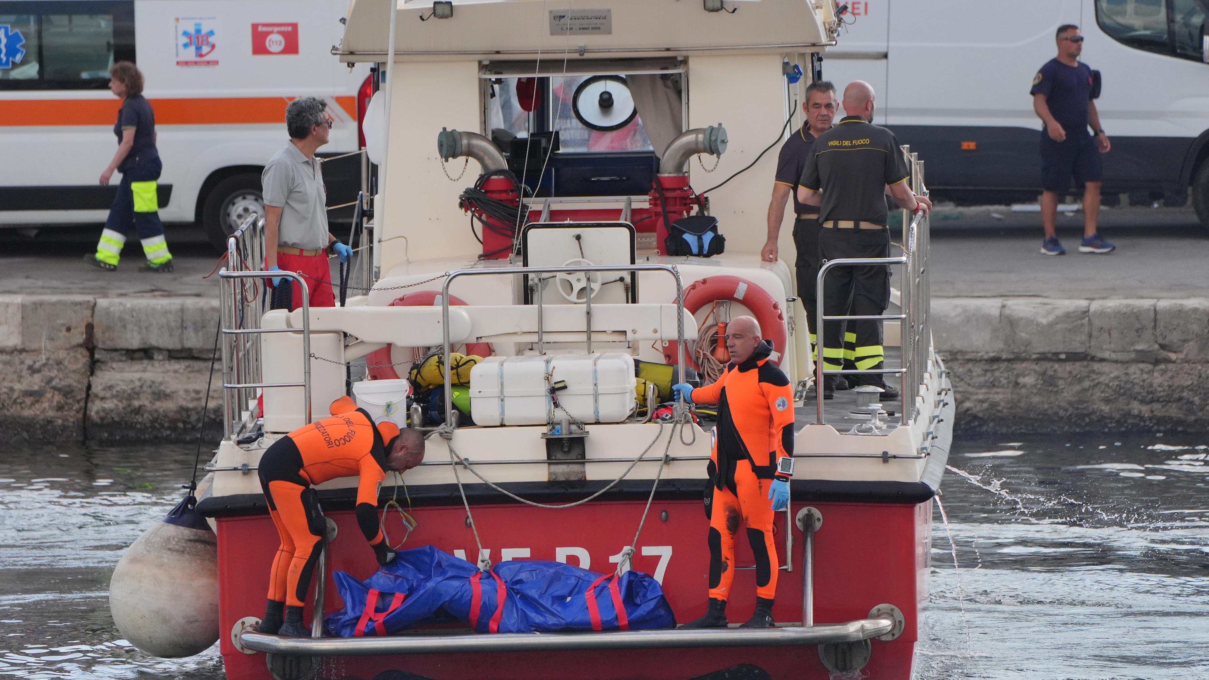 Der fünfte Leichensack wird im Hafen von Porticello von Rettungskräften an Land gebracht, die nach den sechs Touristen suchen, die vermisst werden, nachdem die Luxusyacht Bayesian am Montag in einem Sturm gesunken war, während sie etwa eine halbe Meile vor der sizilianischen Küste festgemacht hatte. 