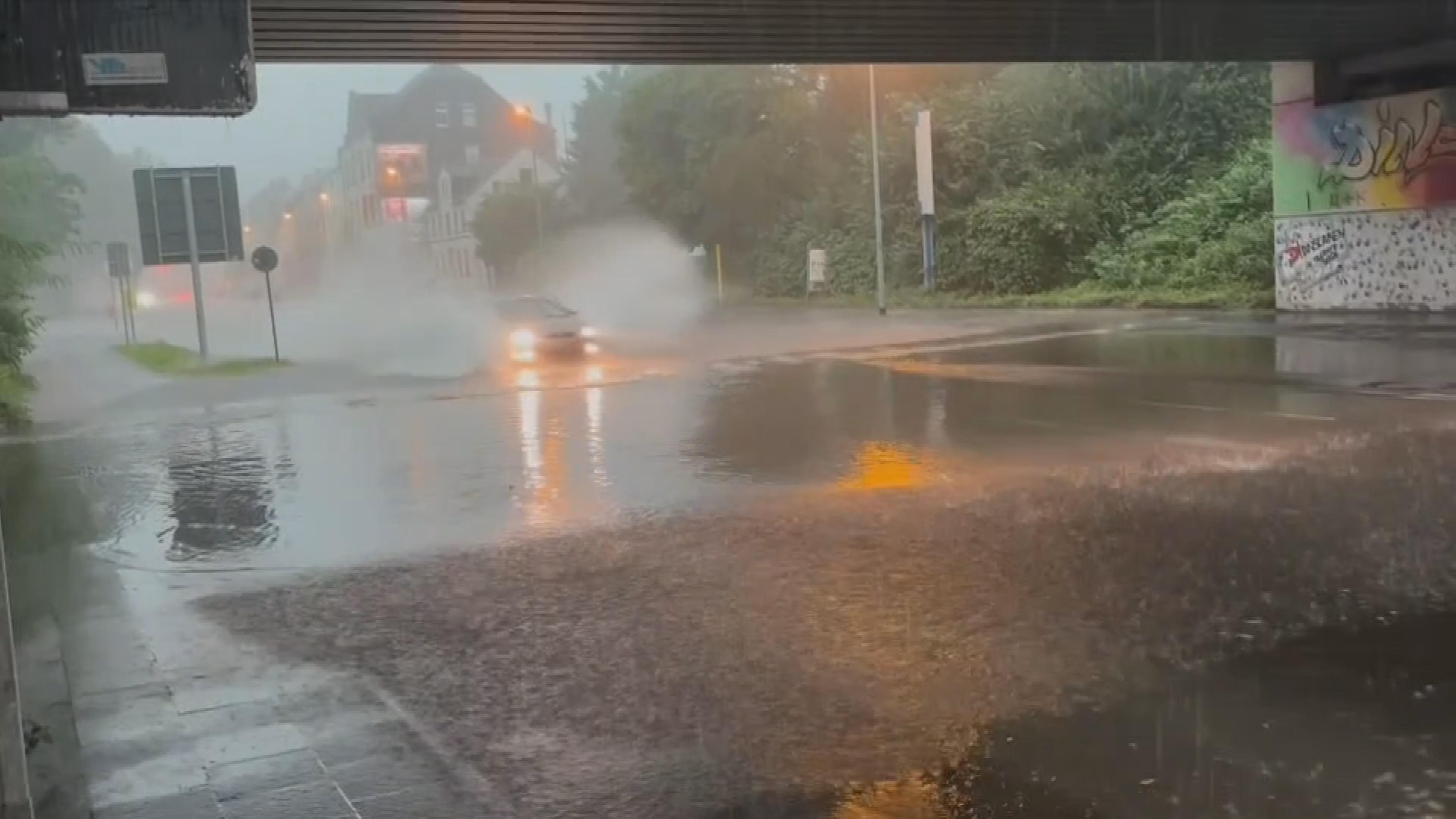 Ein Auto fährt durch eine überflutete Unterführung in Dinslaken in Nordrhein-Westfalen.