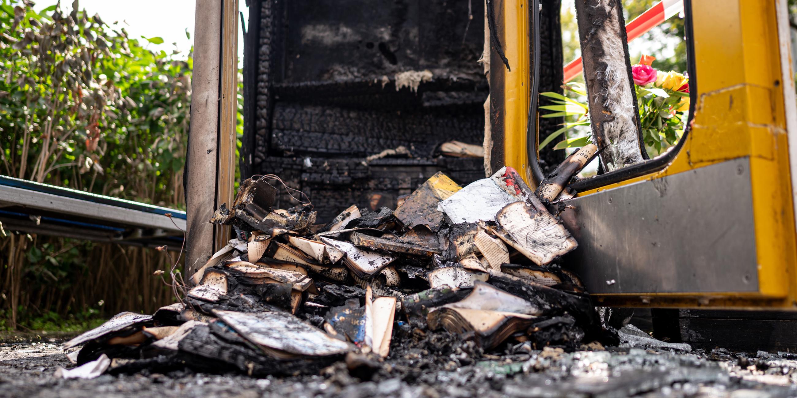 Verbrannte Bücher liegen in der ausgebrannten Bücherbox in der Nähe des Mahnmals "Gleis 17".