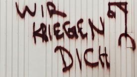 Drohende Graffiti auf einem Baucontainer