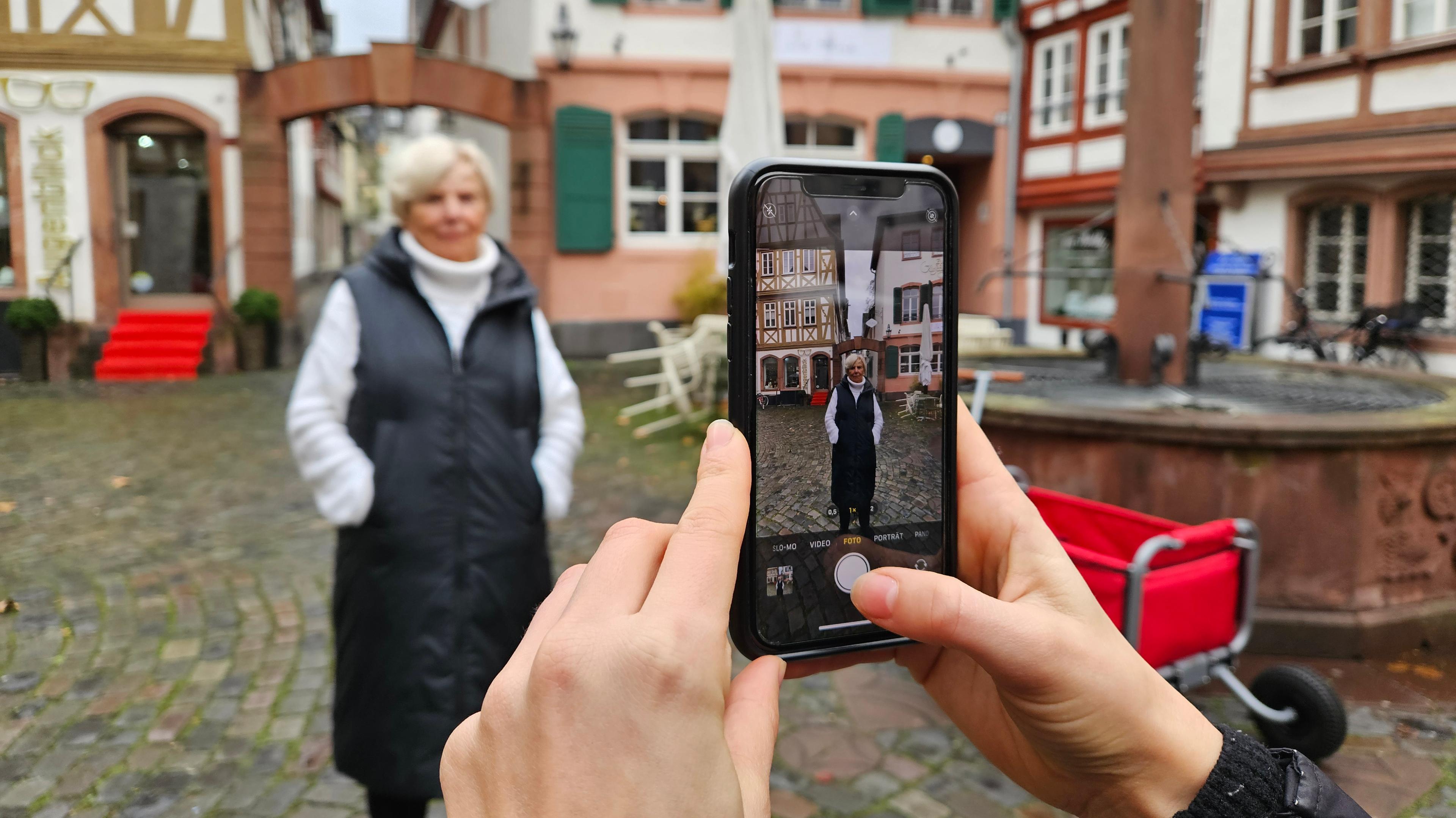 Eine Seniorin wird mit einem Smartphone fotografiert.