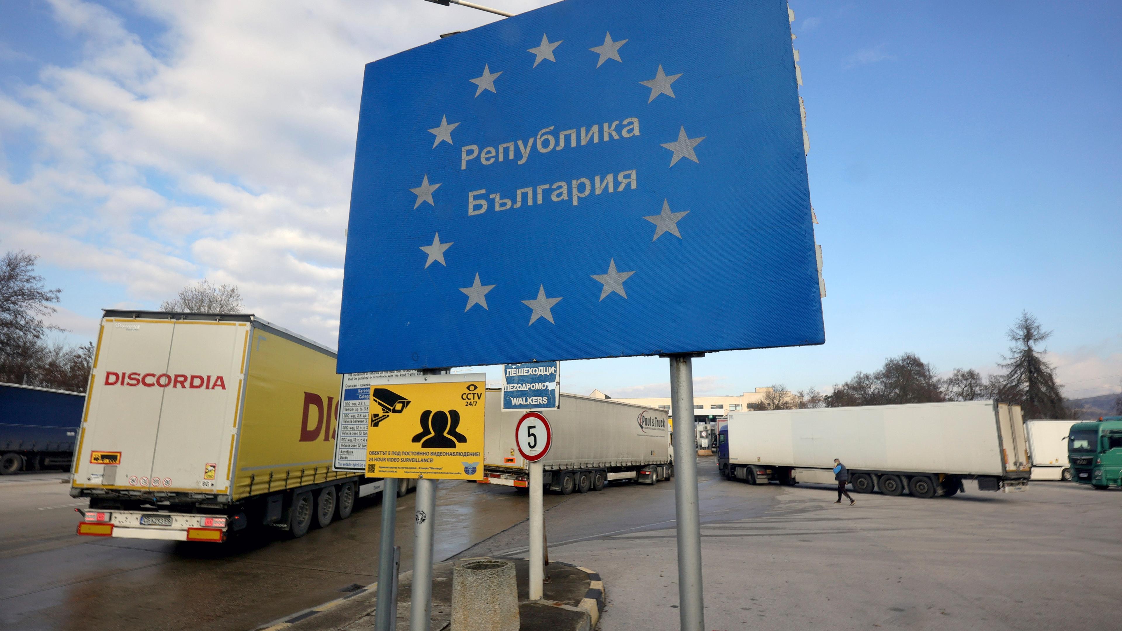 Lastwagen stehen neben einem Schild mit der Aufschrift "Republik Bulgarien" am bulgarisch-griechischen Grenzkontrollpunkt Kulata.