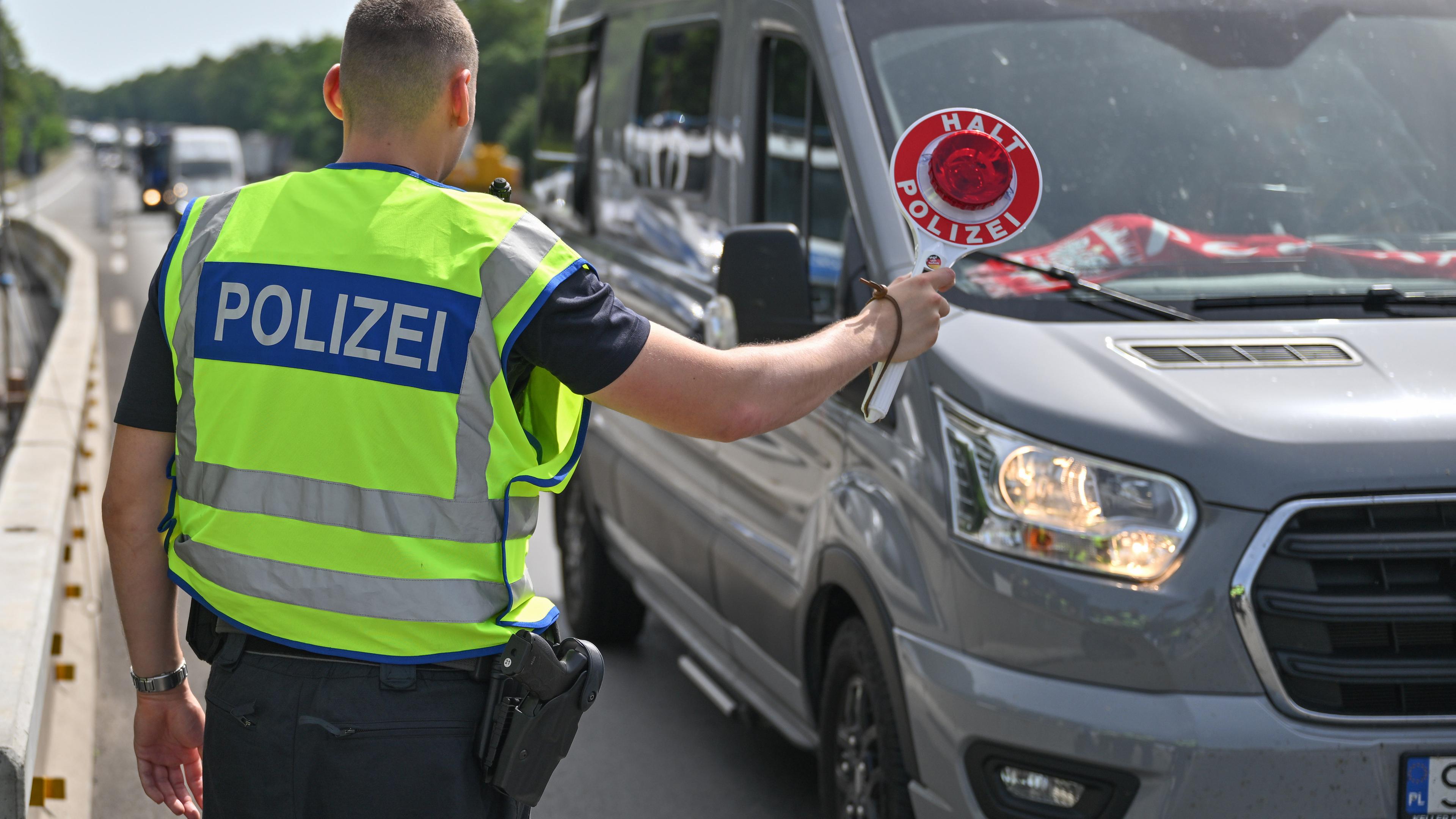 Brandenburg, Frankfurt (Oder): Ein Bundespolizist steht auf der Autobahn A12 nahe dem deutsch-polnischen Grenzübergang und stoppt ein Auto bei der Einreise nach Deutschland.