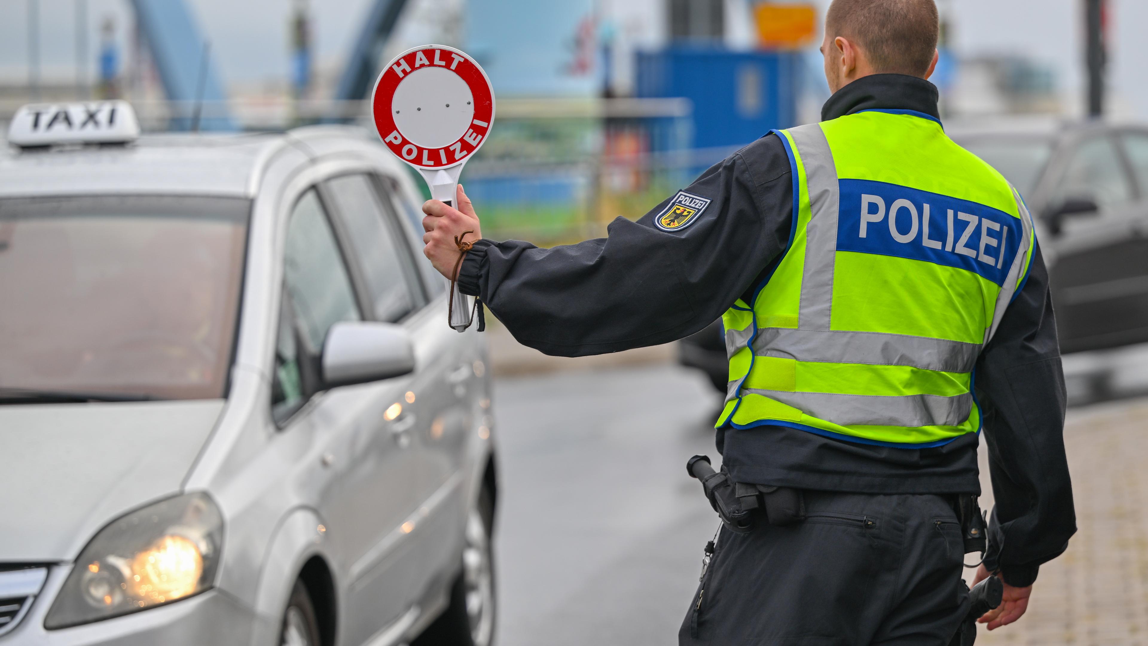 Ein Polizist stoppt an der deutsch-polnischen Grenze einen Wagen.