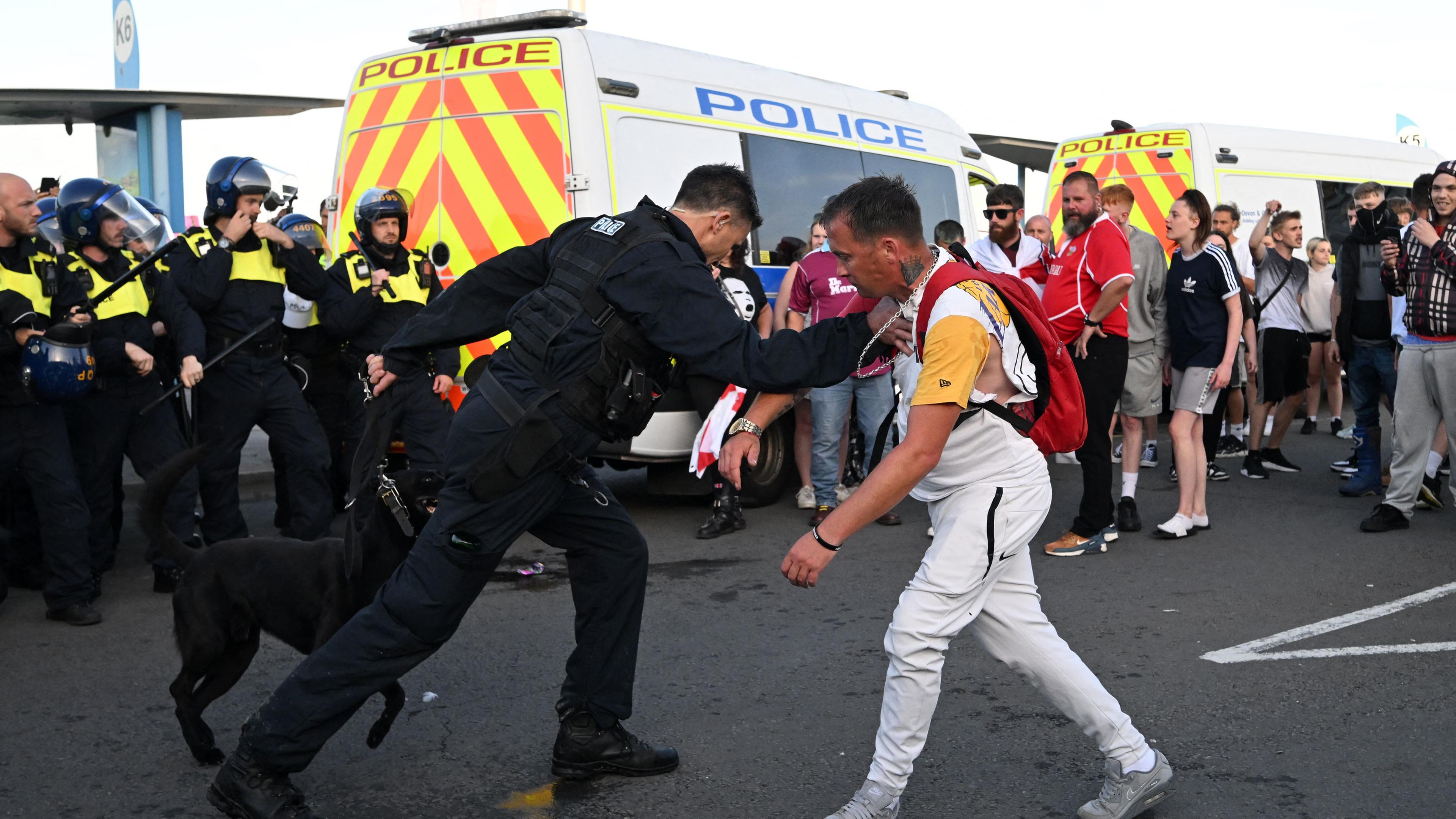 Ein Polizeibeamter hält einen Demonstranten während einer von rechtsextremen Aktivisten aufgerufenen „Genug ist genug“-Demonstration in Weymouth an der Südwestküste Englands fest