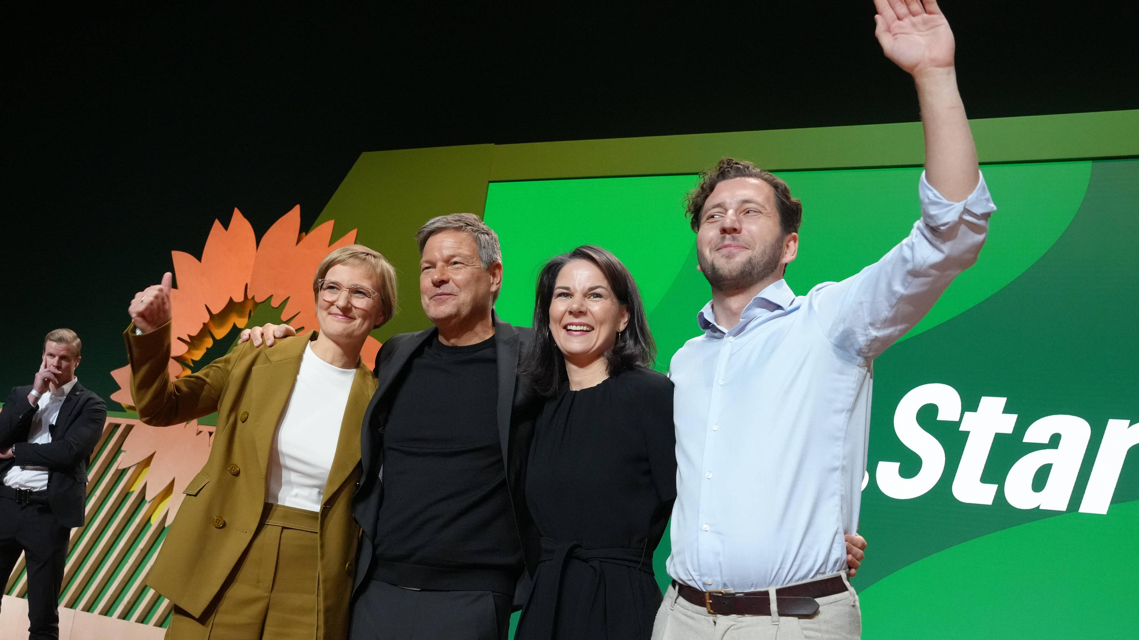 Die Parteispitze der Gruenen um Felix Banaszak, Annalena Baerbock, Robert Habeck und Franziska Brantner jubeln gemeinsam auf der Buehne