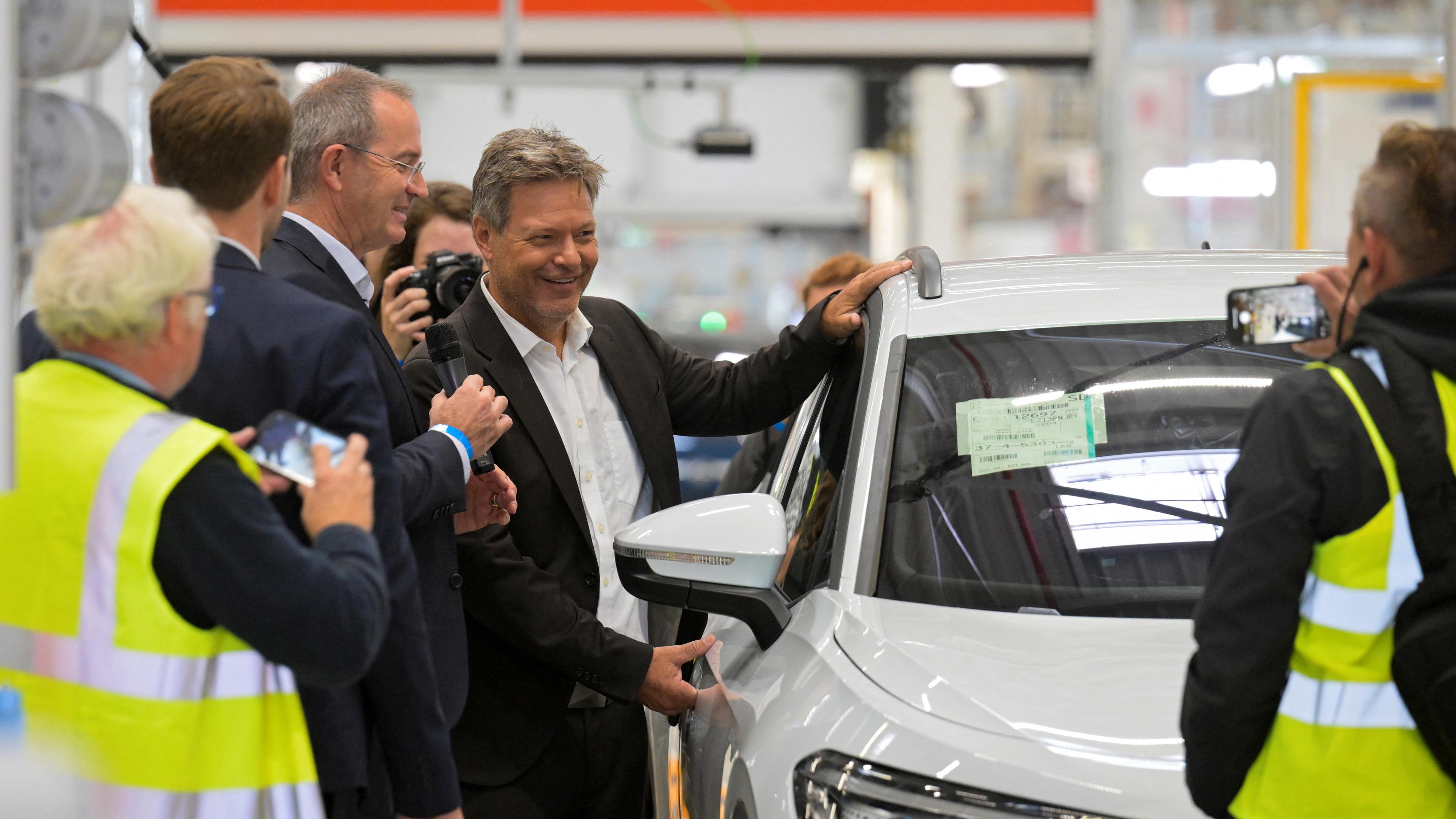 German Economy Minister Robert Habeck poses beside a Volkswagen car during his visit at a Volkswagen plant in Emden