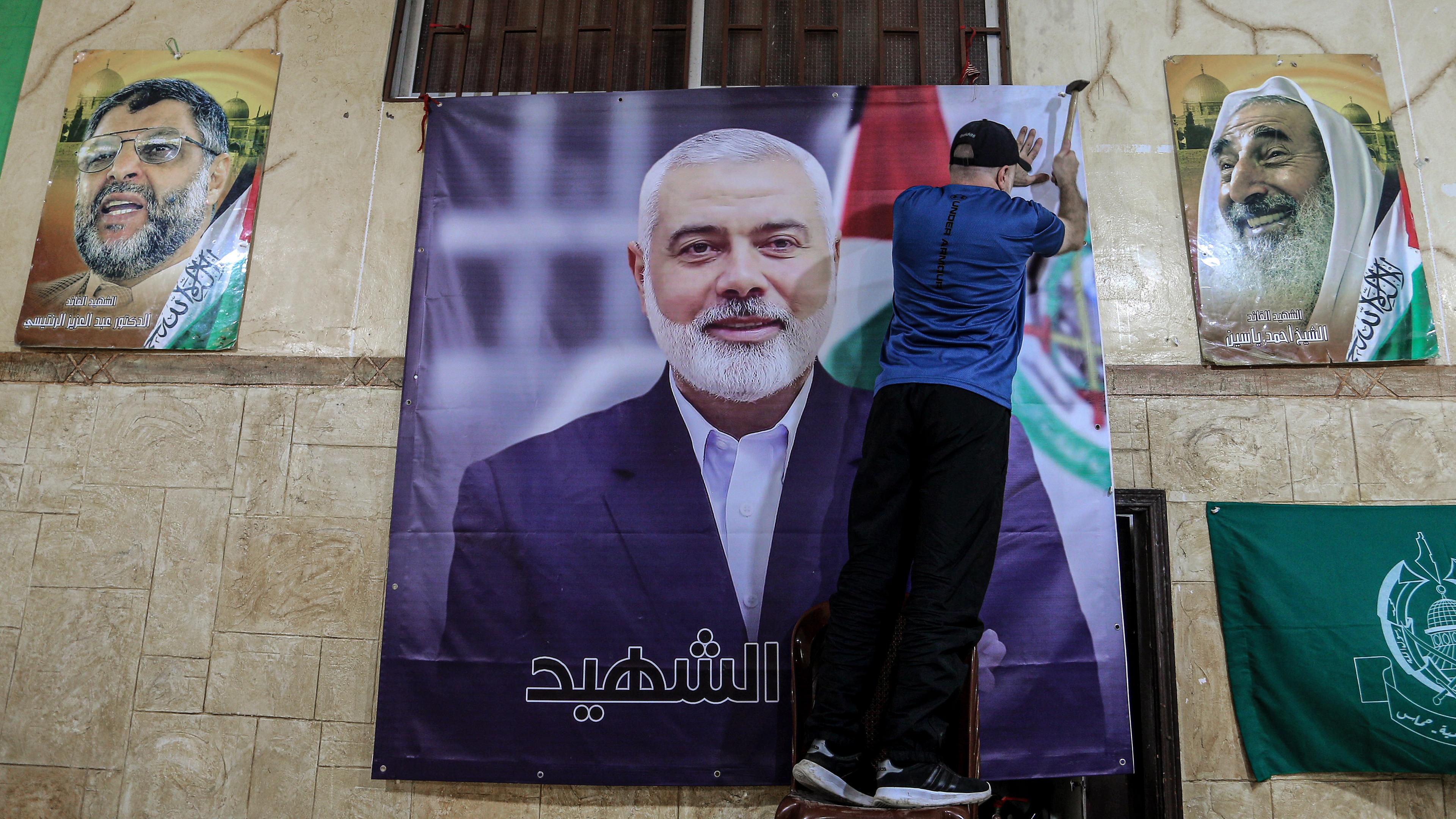 Libanon, Beirut: Ein Palästinenser hängt ein großes Bild von Ismail Hanija in einer Halle im palästinensischen Flüchtlingslager Burj al-Brajneh auf. 