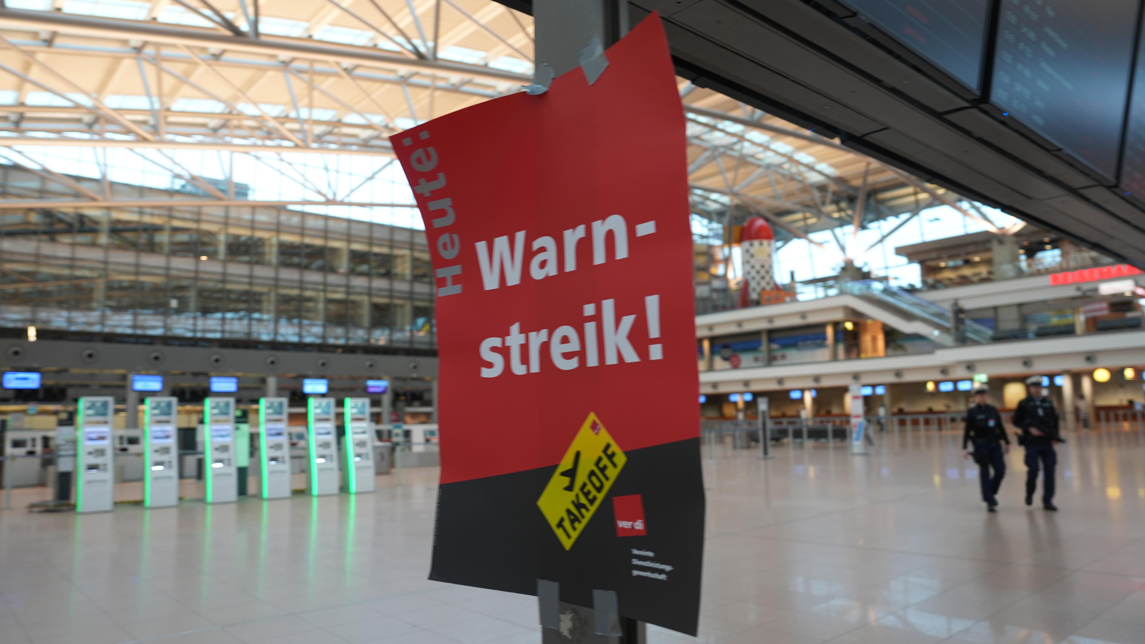 Ein Schild mit der Aufschrift ·Warnstreik!· hängt im Terminal 1 im Flughafen Hamburg Airport.