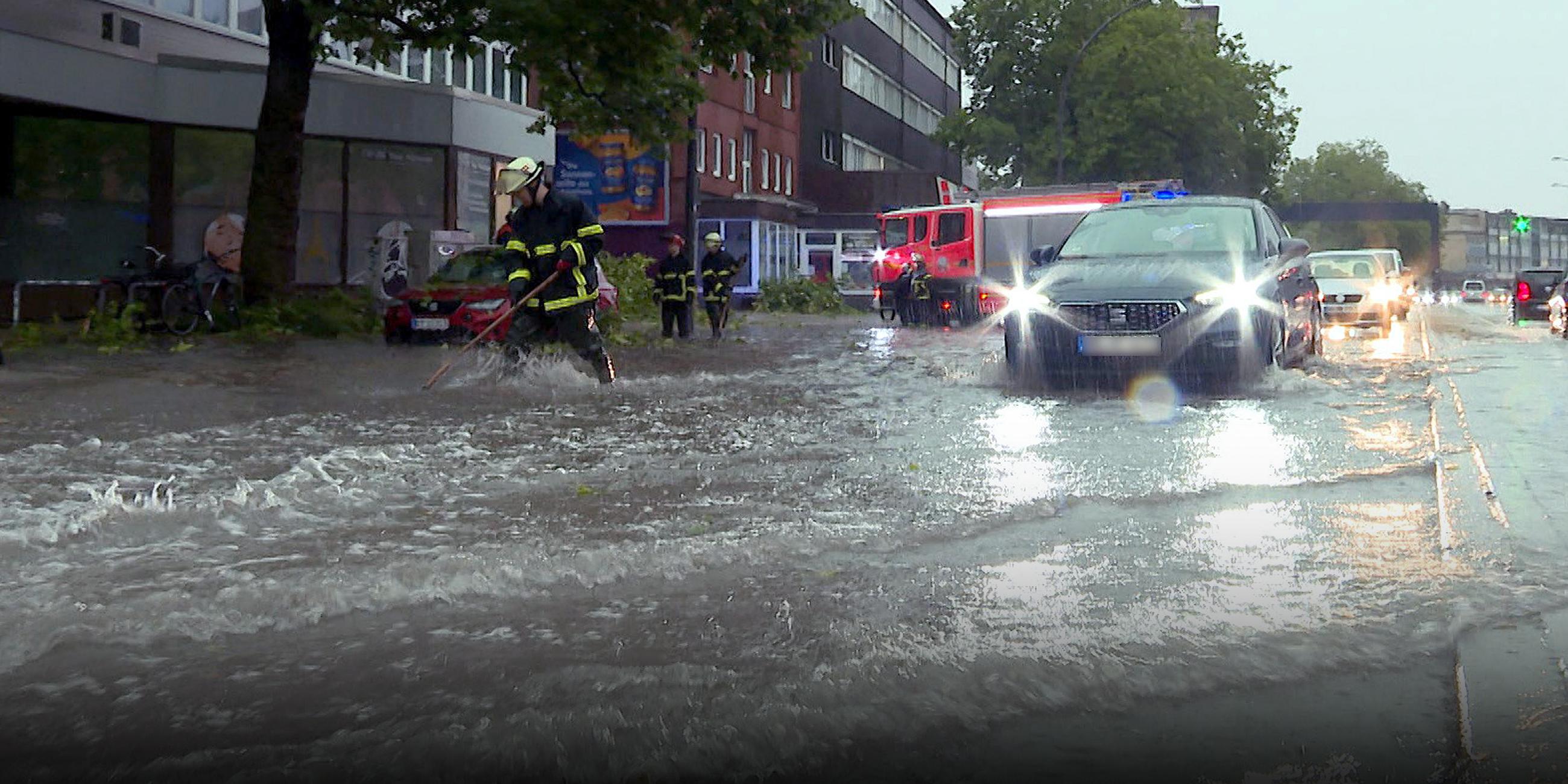 Ein Auto fährt auf einer überschwemmten Straße in Hamburg.