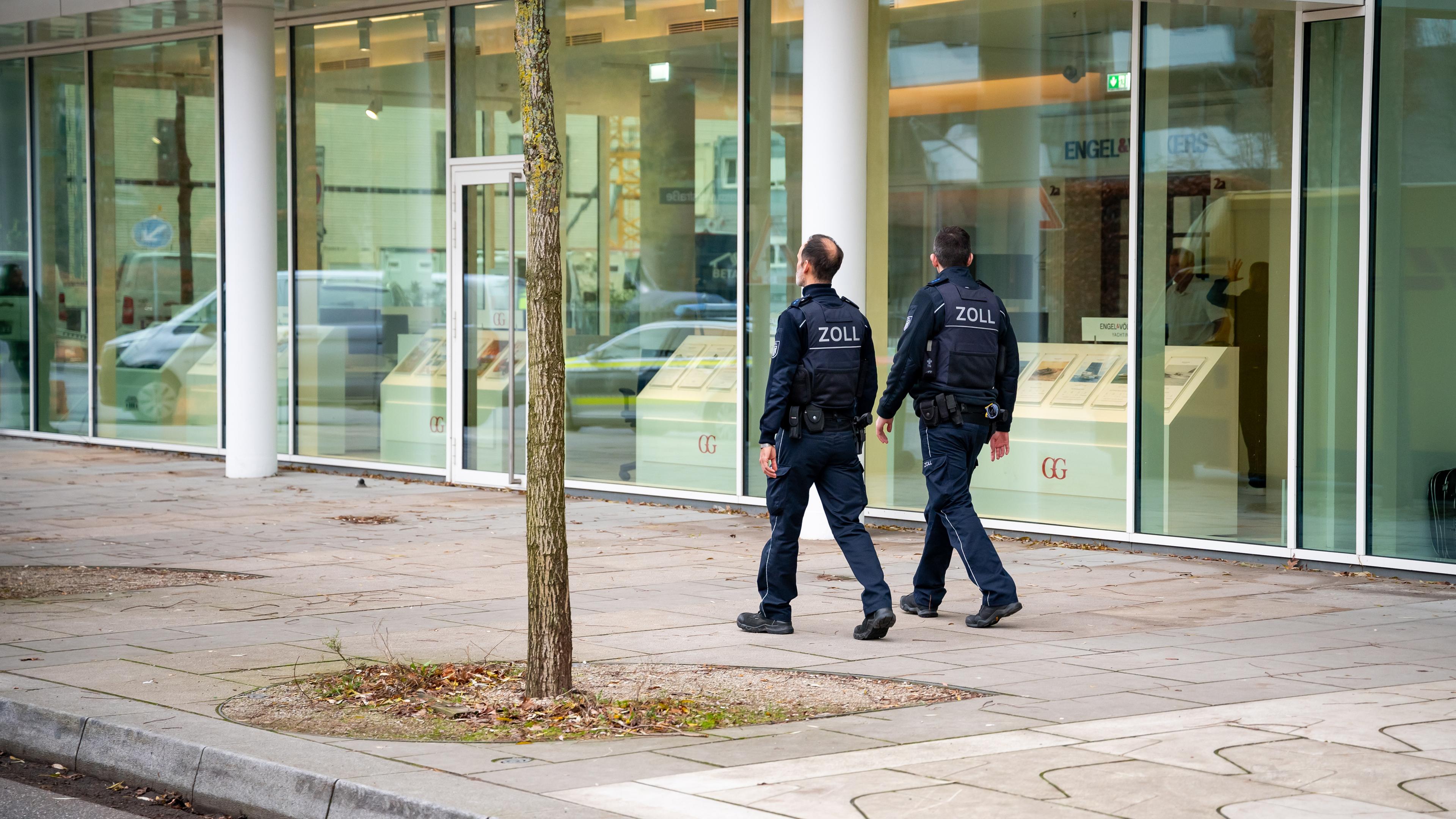 Hamburg: Zoll-Beamte vor dem Gebäude eines Unternehmenssitzes.