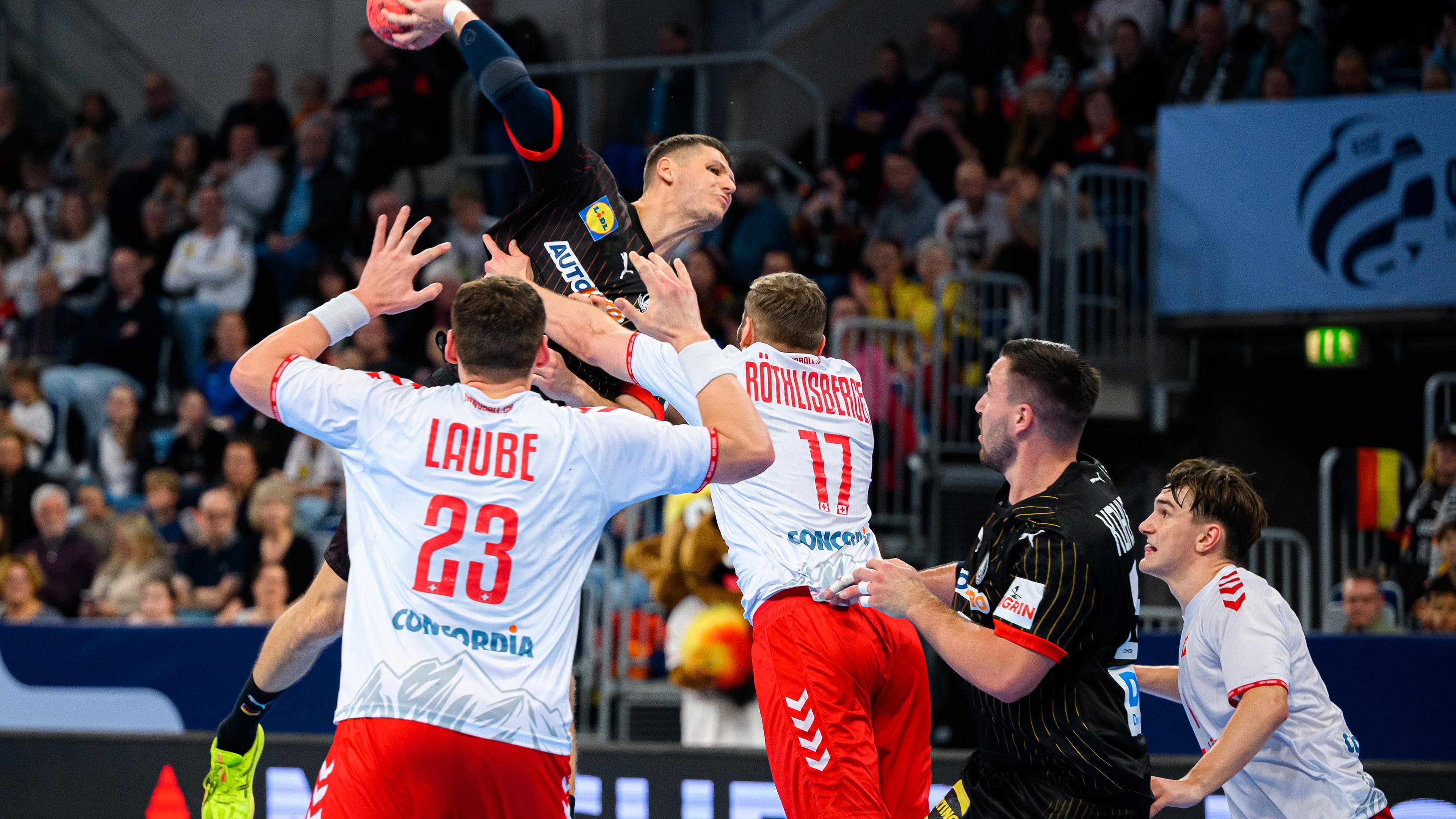 Baden-Württemberg, Mannheim: Handball: EM-Qualifikation, Deutschland - Schweiz, 2. Qualifikationsrunde, Gruppe 7, 1. Spieltag, Die Schweizer Spieler Lukas Laube (l) und Samuel Röthlisberger (M) in Aktion gegen Deutschlands Spieler Sebastian Heymann (2.v.l) und Jannik Kohlbacher (2.v.r).