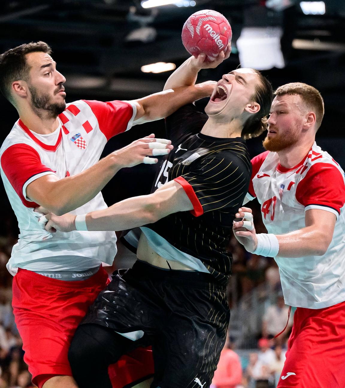 Der deutsche Handballer Juri Knorr im Zweikampf mit den Kroaten Zvonimir Srna und Nikola Grahovac.