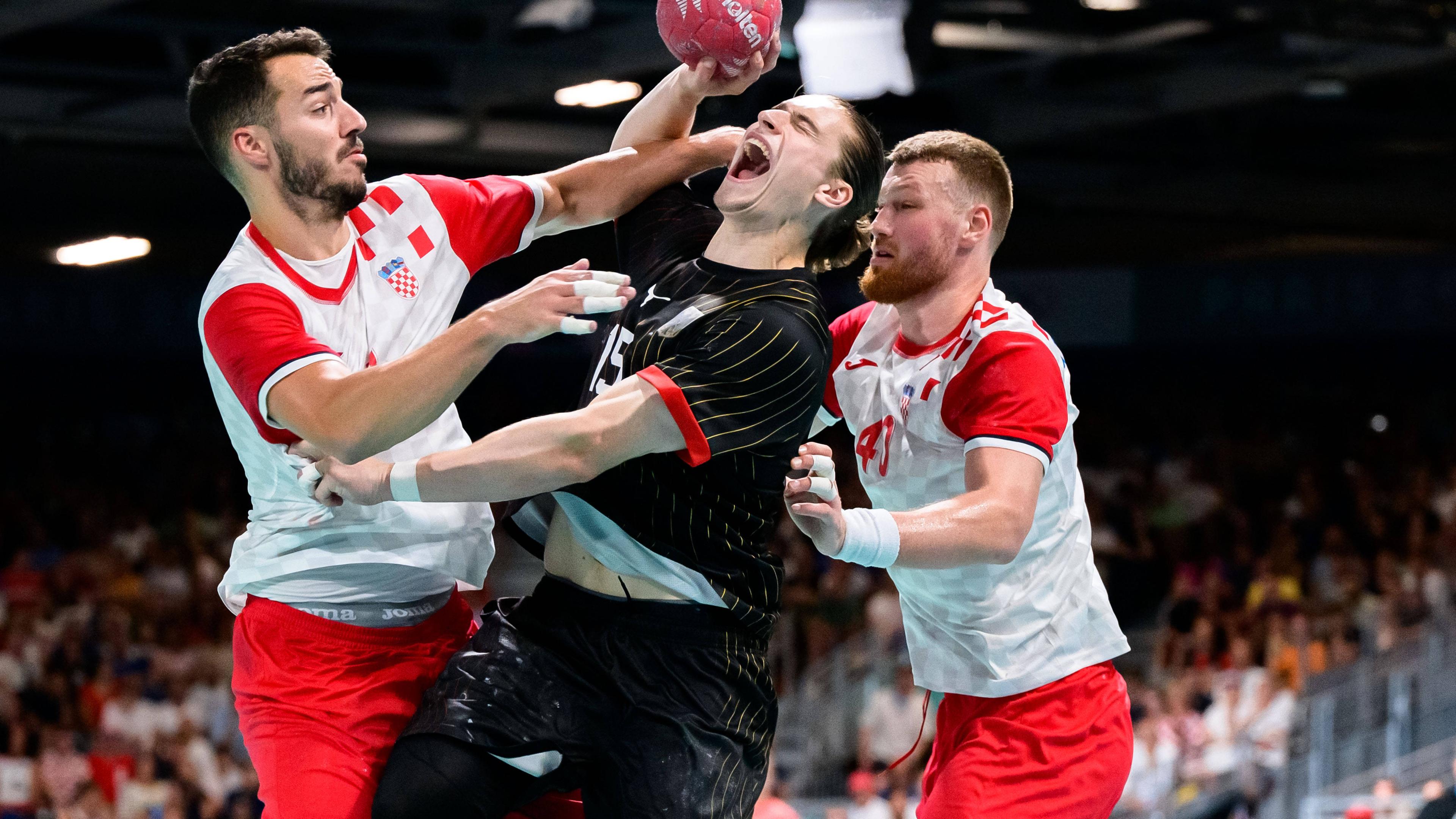 Der deutsche Handballer Juri Knorr im Zweikampf mit den Kroaten Zvonimir Srna und Nikola Grahovac.