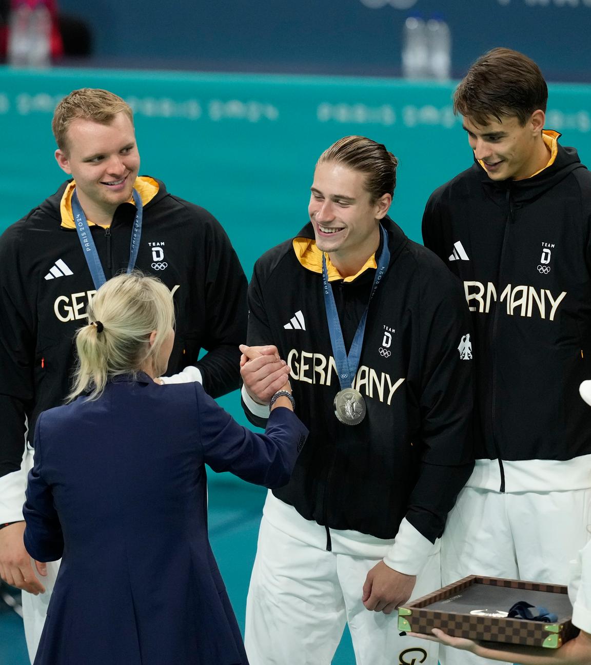 IOC-Mitglied Britta Heidemann überreicht an die deutschen Handballer die olympische Silbermedaille am 11.8.2024.