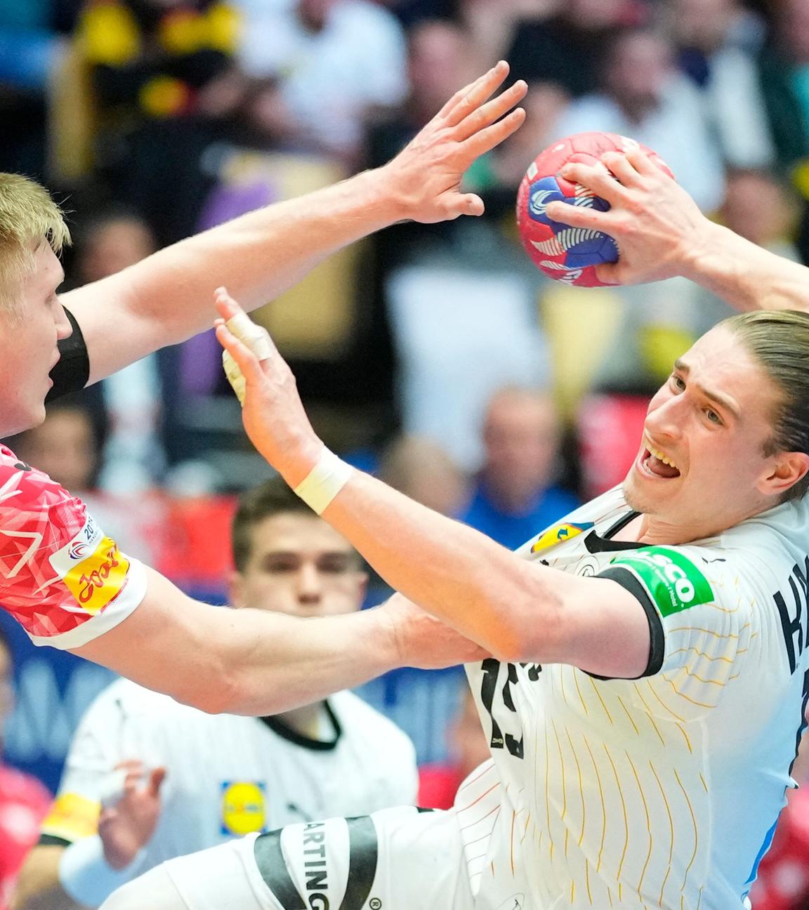 Deutschlands Juri Knorr und Polens Ariel Pietrasik kämpfen um den Ball beim Gruppenspiel der Handball-WM.