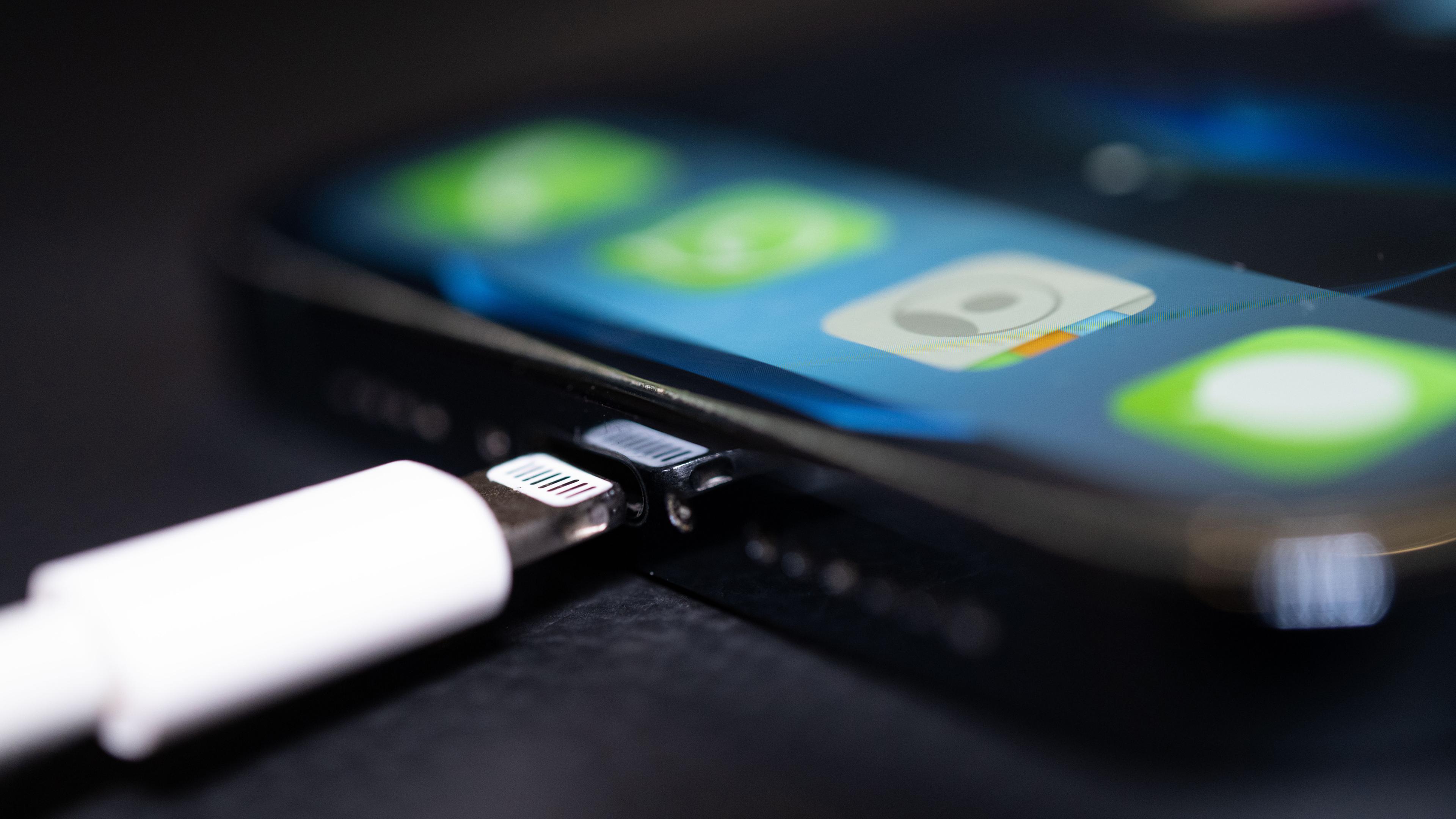 Ein Lightning-Ladestecker wird in ein Apple iPhone gesteckt.