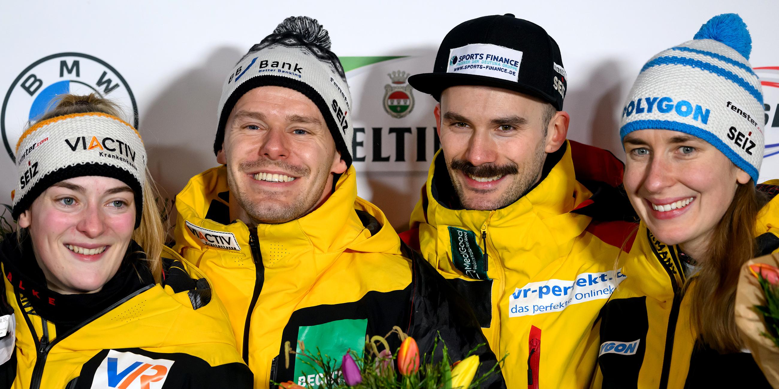 Das Siegerteam Hannah Neise und Christopher Grotheer aus Deutschland stehen nach dem Sieg auf dem Podium neben den Drittplatzierten Axel Jungk und Jacqueline Pfeifer aus Deutschland.