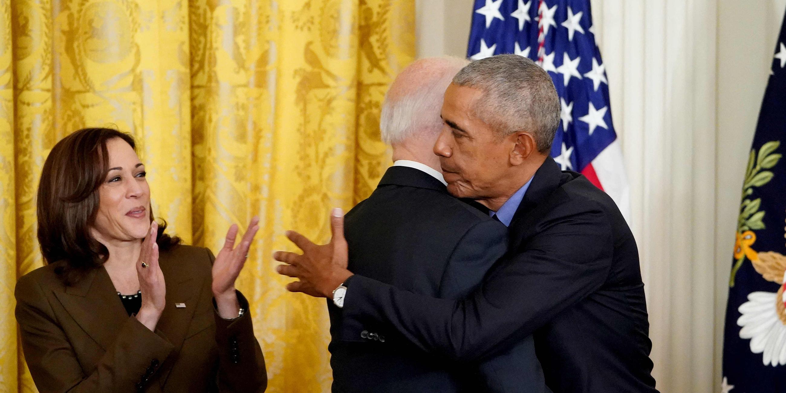 US-Vizepräsidentin Kamala Harris applaudiert, während US-Präsident Joe Biden und der ehemalige Präsident Barack Obama sich umarmen (Archiv 2022)