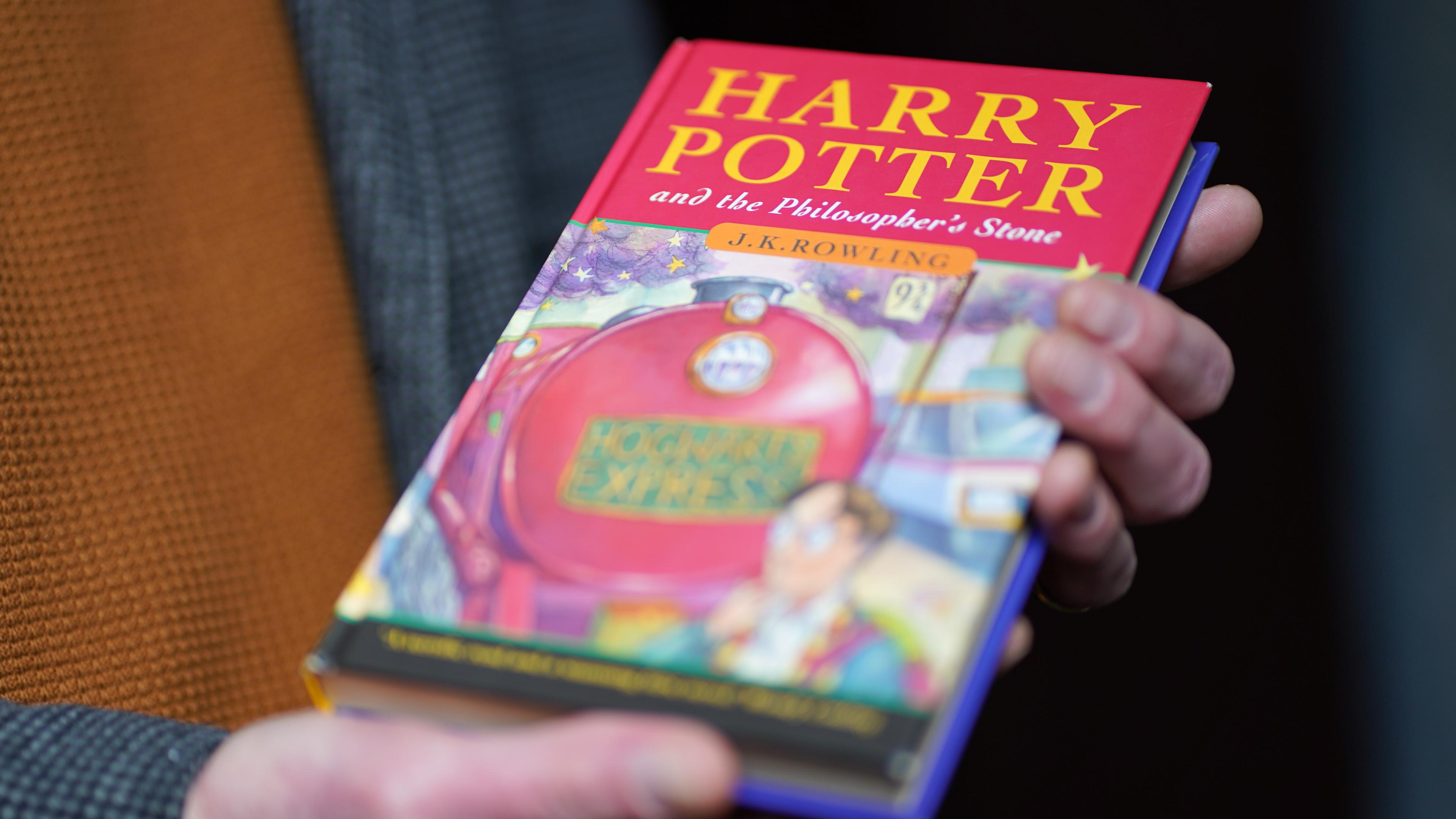 Großbritannien, Stafford: Auktionator Jim Spencer hält eine makellose Erstausgabe von J.K. Rowlings des Harry-Potter-Bands «Der Stein der Weisen» («The Philosopher's Stone») in der Hand.