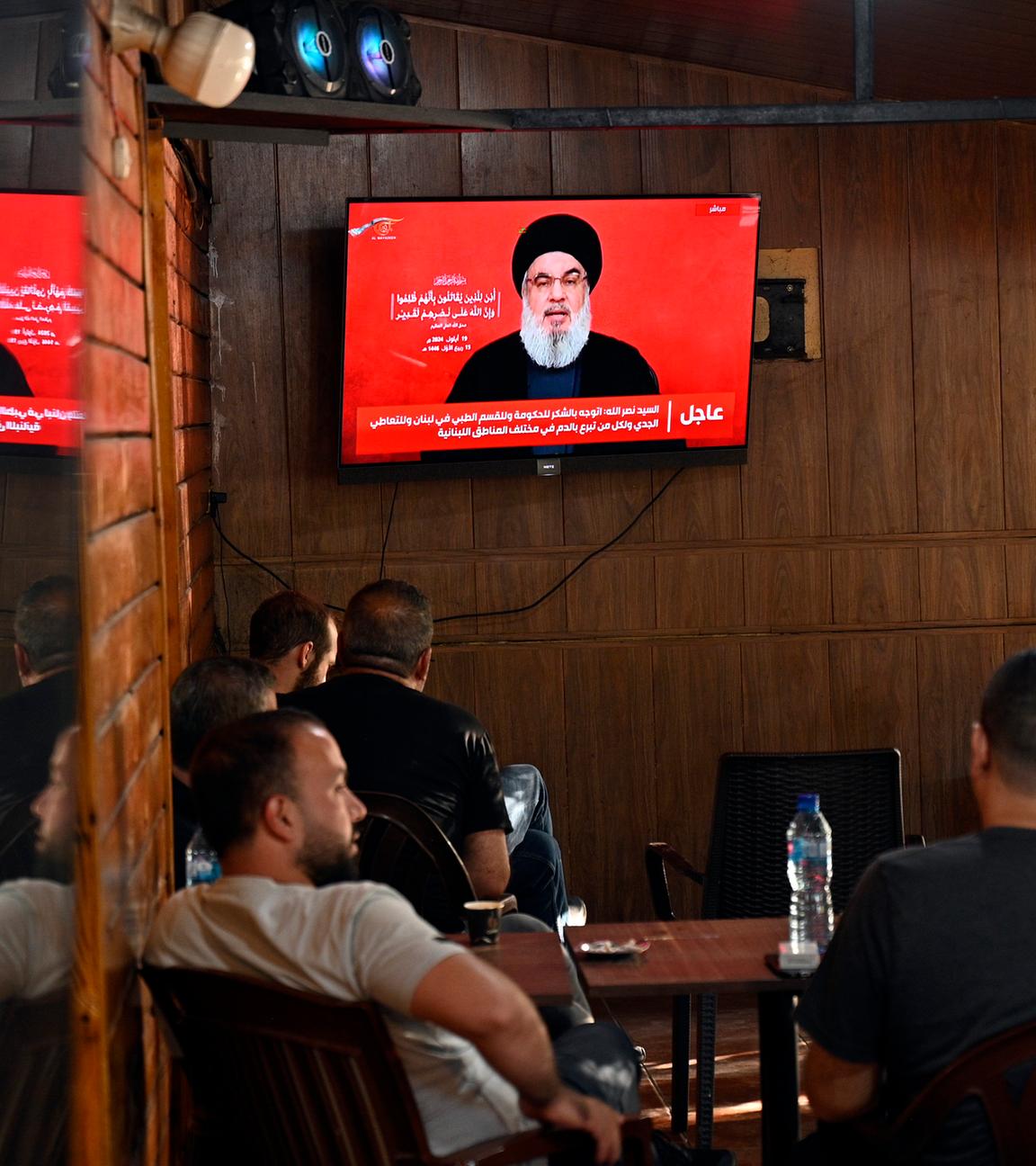 Menschen verfolgen eine im Fernsehen übertragene Rede von Hisbollah-Generalsekretär Hassan Nasrallah in einem Café in einem südlichen Vorort von Beirut.