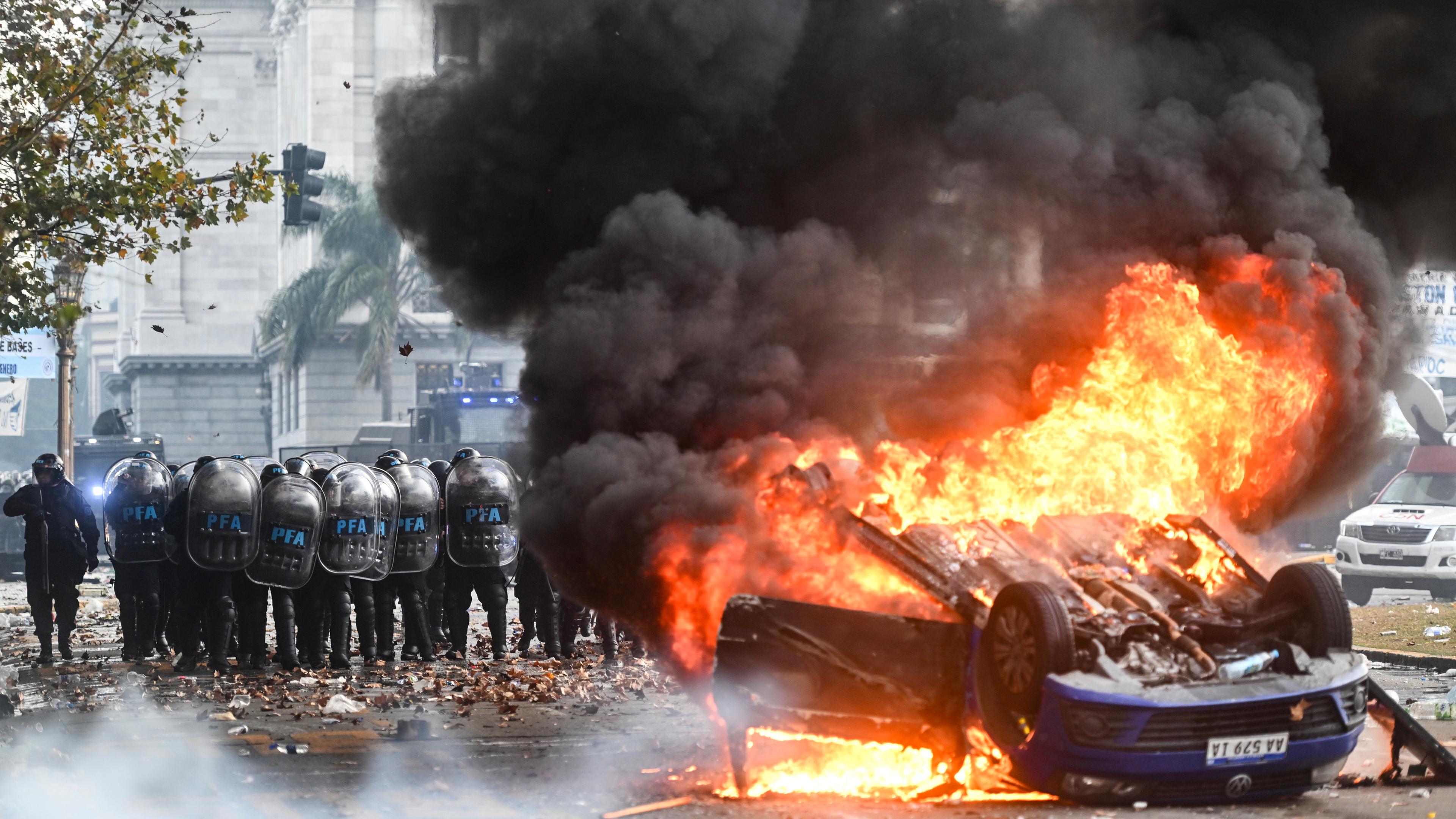 Ein Volkswagen-Pkw brennt vor dem Kongress während eines Protests gegen das Reformvorhaben der ultraliberalen Regierung von Präsident Milei, das im Kongress debattiert wird. 