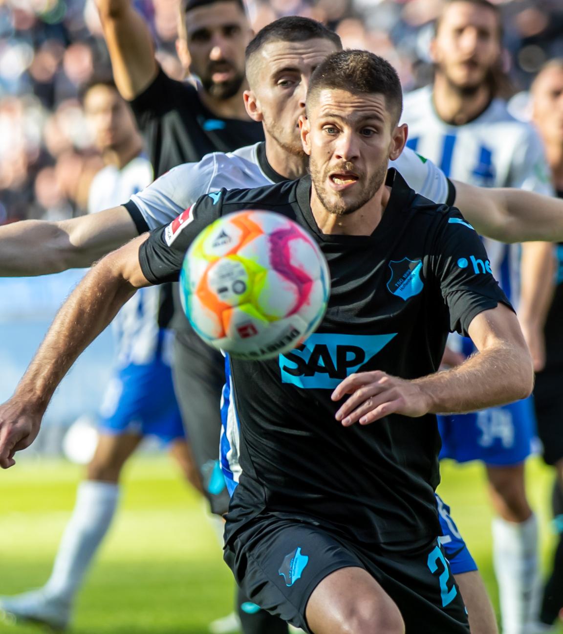 2.10.2022, Berlin: Fußball: Bundesliga, Hertha BSC - TSG 1899 Hoffenheim, 8. Spieltag, Olympiastadion. Berlins Jonjoe Kenny (l) kämpft gegen Andrej Kramaric von TSG Hoffenheim um den Ball.