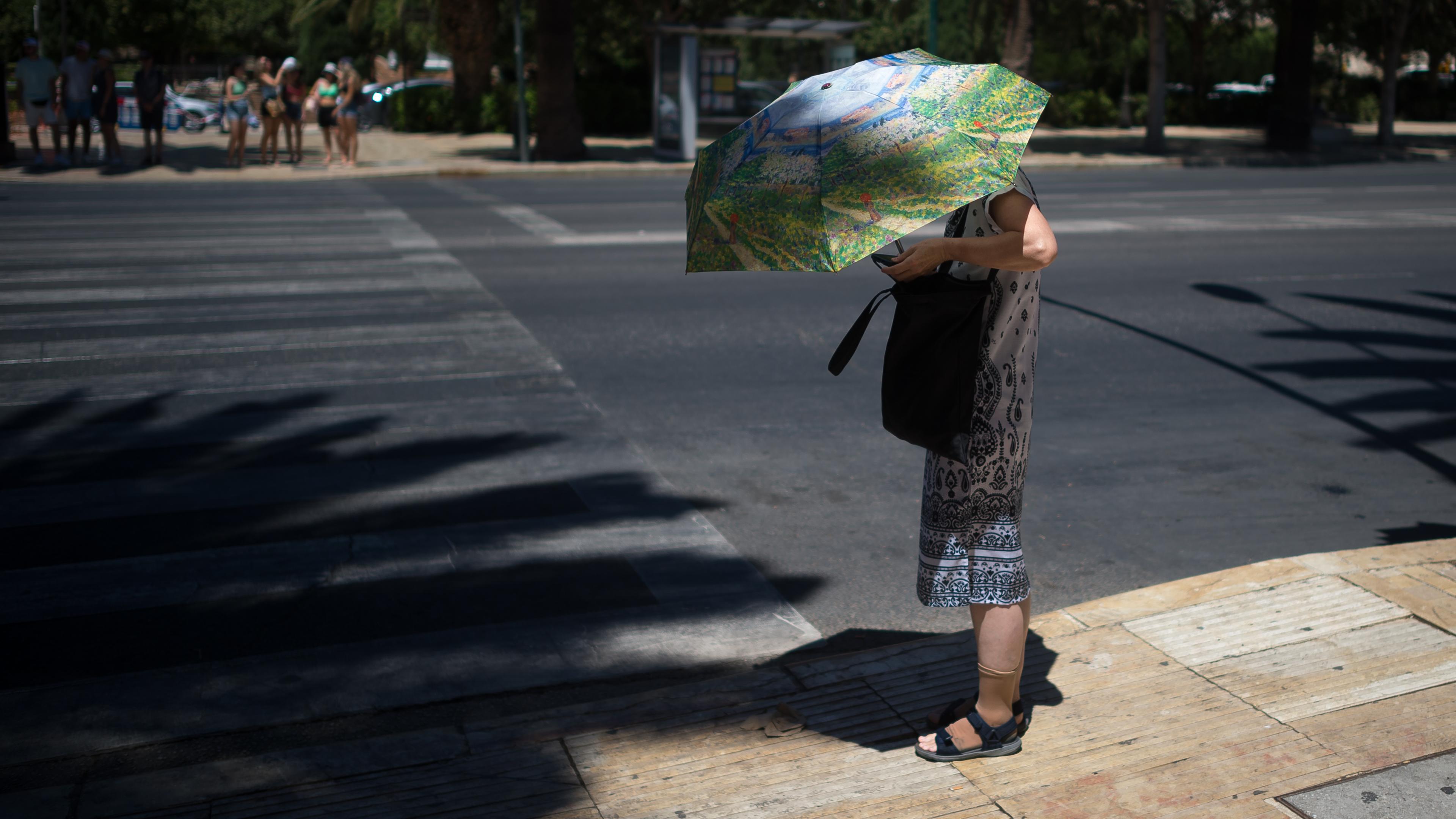Archiv: Eine Touristin benutzt einen Regenschirm, um sich an einem heißen Sommertag in Málaga, Spanien, am 03.08.2023 vor der Sonne zu schützen.