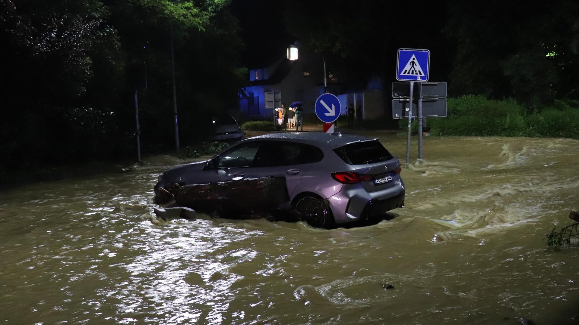 Ein Auto steht auf einer überfluteten Straße in der Stadt Ebersbach 