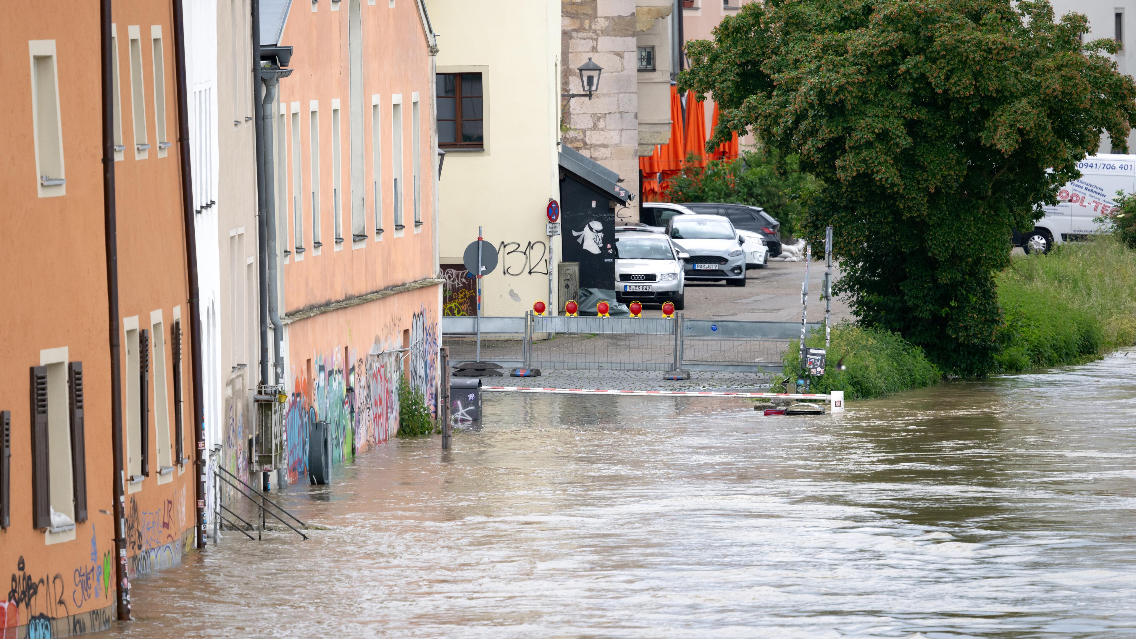 05.06.2024, Bayern, Regensburg: Die Donau fließt in der Altstadt an den Häusern entlang. Seit Tagen kämpfen die Helfer in Bayern gegen die Flut und ihre Folgen.