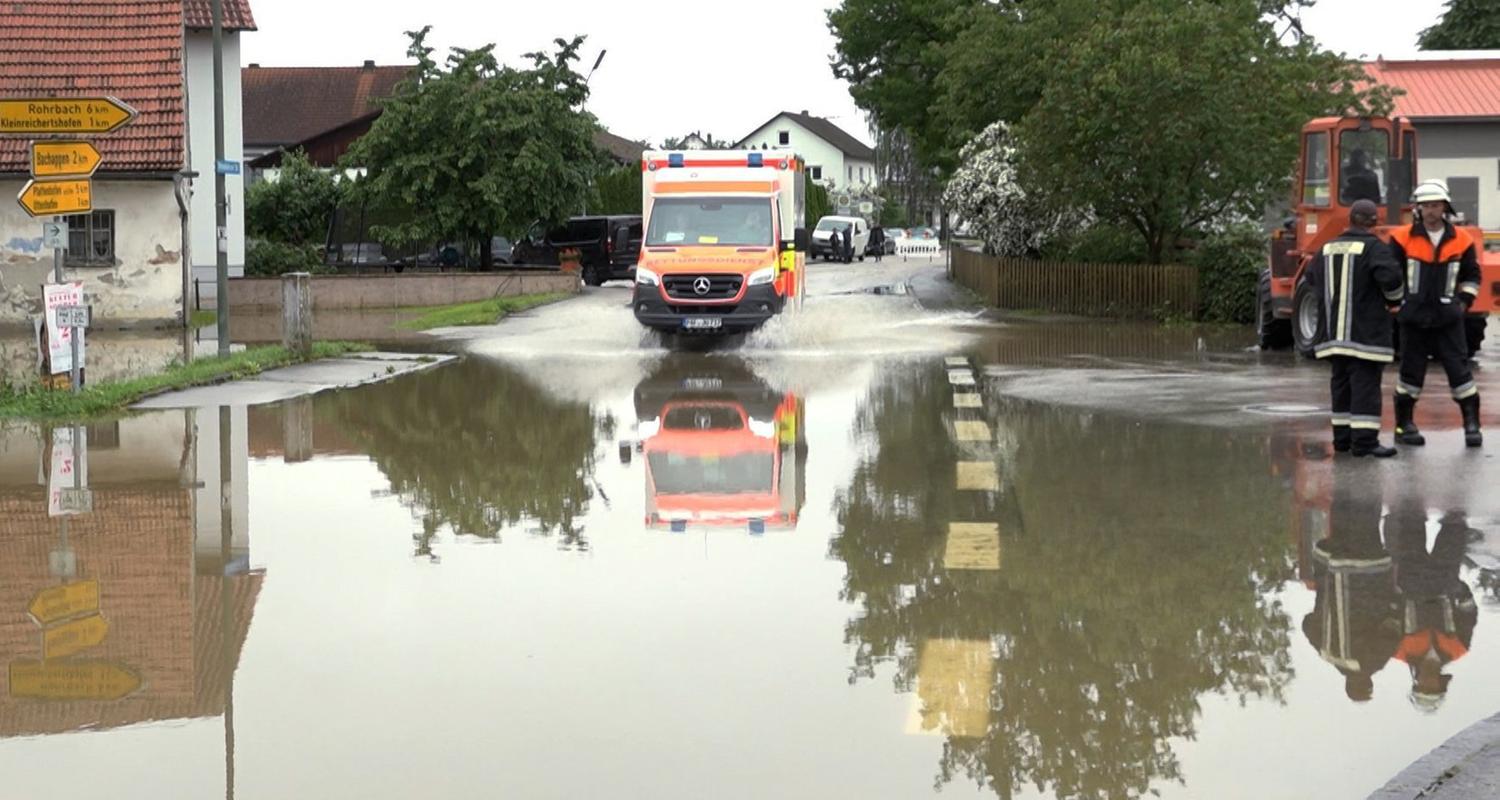 Bayern, Pfaffenhofen an der Ilm: Ein Krankenwagen fährt über eine überschwemmte Straße in Pfaffenhofen an der Ilm.