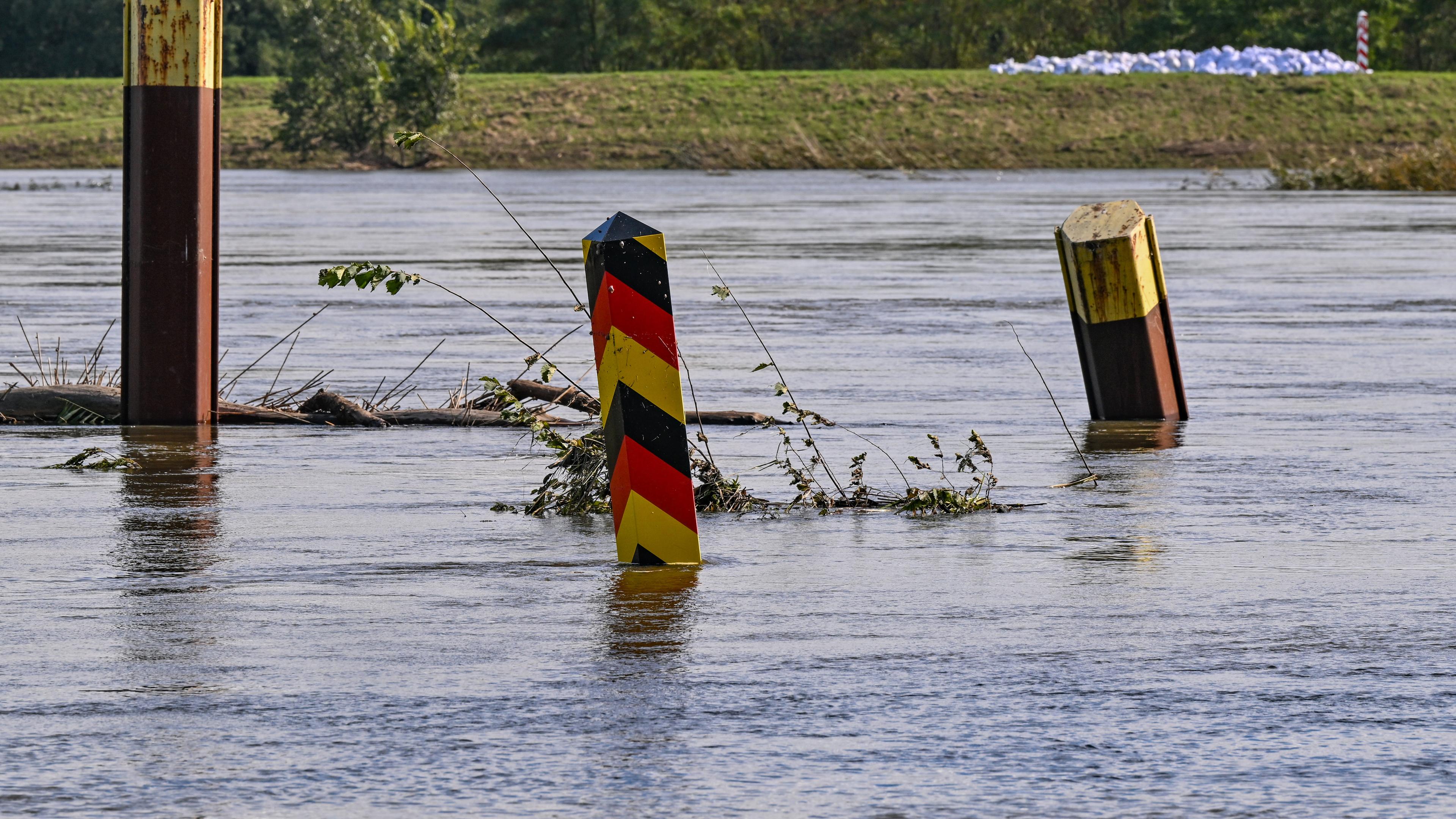 Brandenburg, Lebus: Ein Grenzpfeiler, der sonst auf dem Trockenen steht, ragt aus dem Hochwasser des Flusses Oder und wurde von der Strömung verbogen.