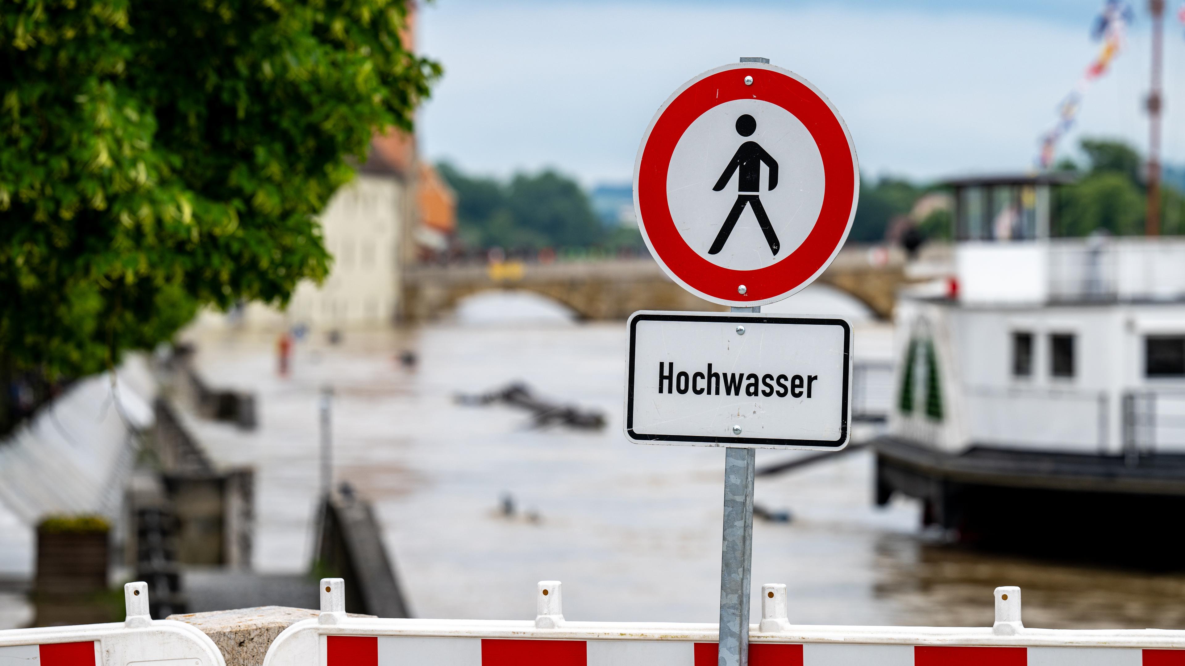 Bayern, Regensburg: Ein Hochwasser Warnschild steht am Ufer der Donau.