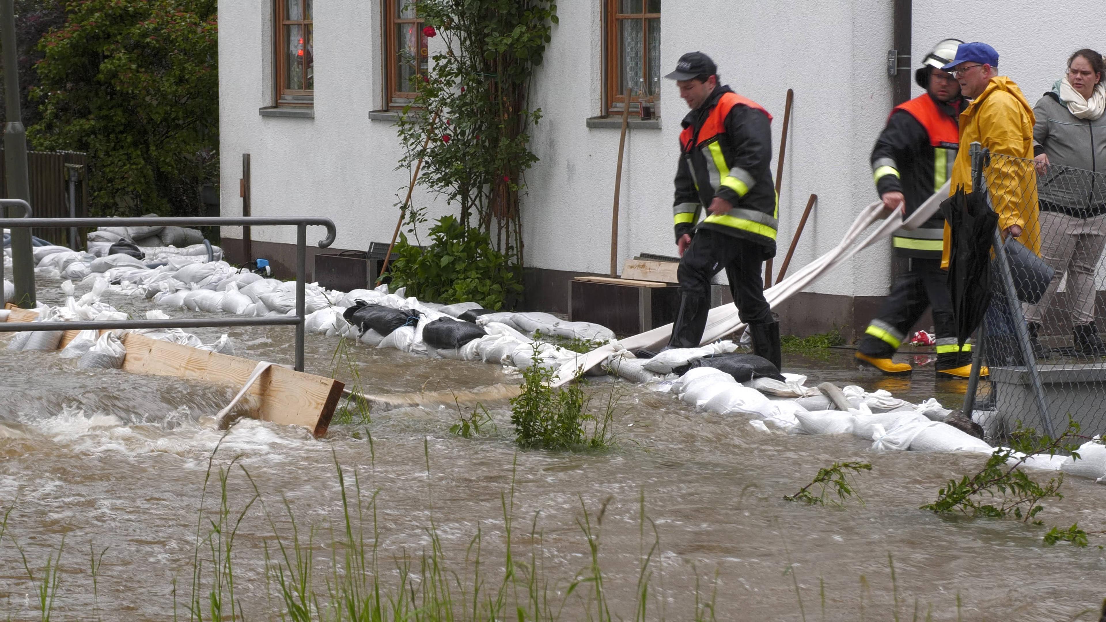 Das Wasser schießt über die Dämme hinweg und überflutet Ortschaft Zell bei Bad Grönenbach