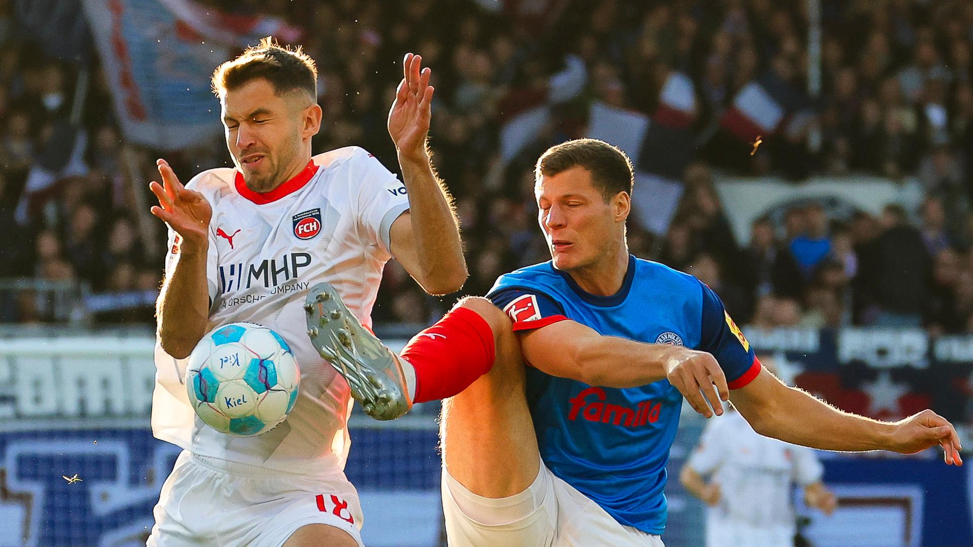 Heidenheims Marvin Pieringer (l) und Kiels Patrick Erras kämpfen um den Ball. 