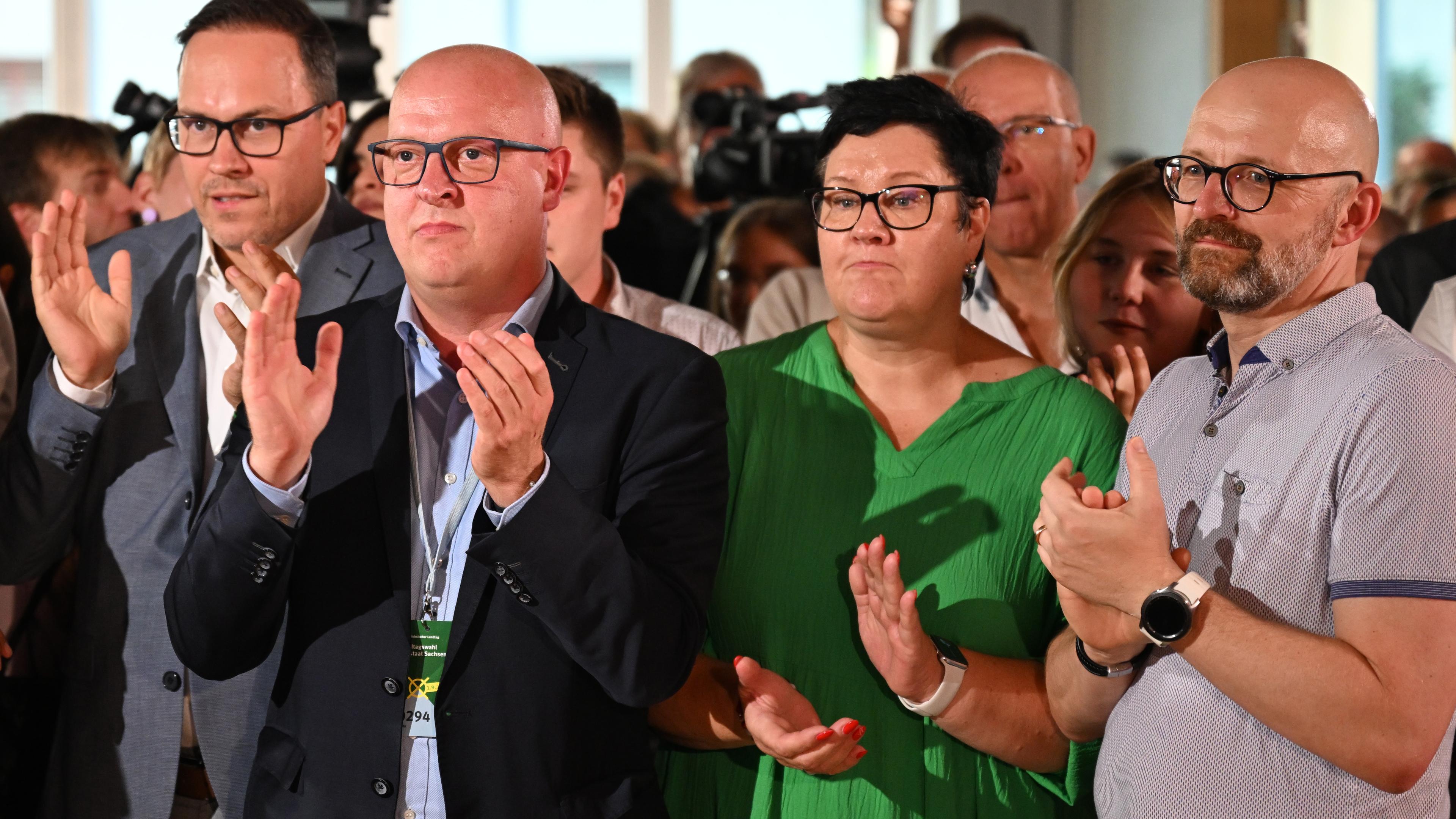 Dirk Panter (l-r), Vorsitzender der SPD-Fraktion im sächsischen Landtag, Henning Homann, Co-Vorsitzender der SPD Sachsen, und Kathrin Michel, Co-Vorsitzende der SPD Sachsen applaudieren nach der Verkündung der ersten Hochrechnungen. 