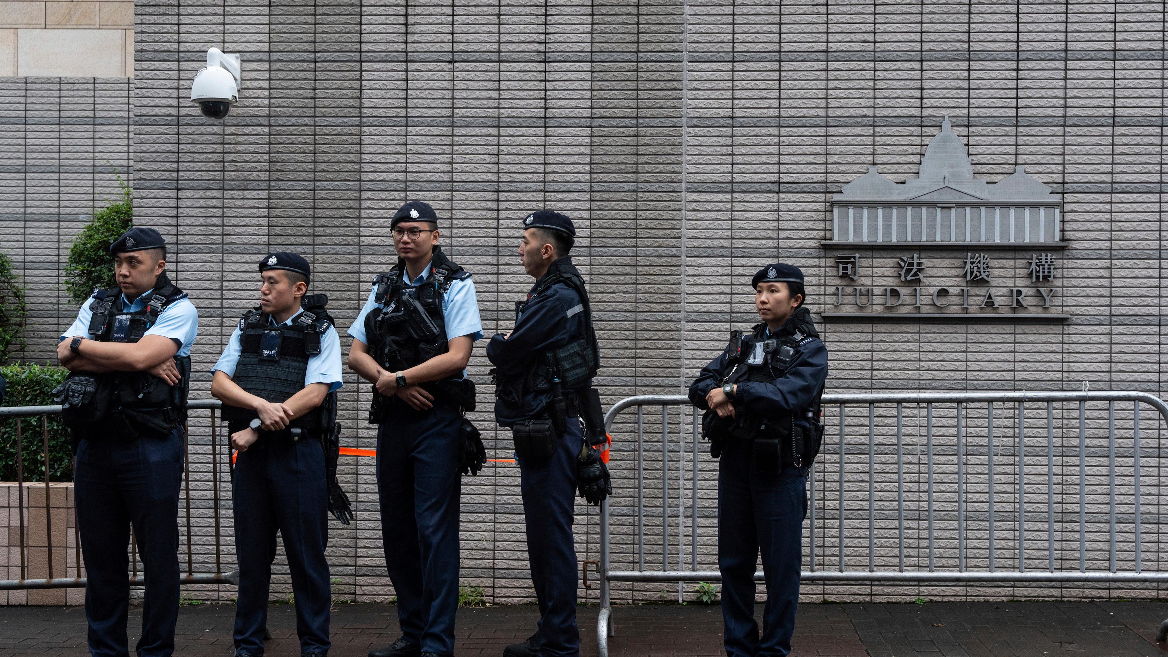 Polizisten stehen vor dem Amtsgericht West Kowloon in Hongkong Wache