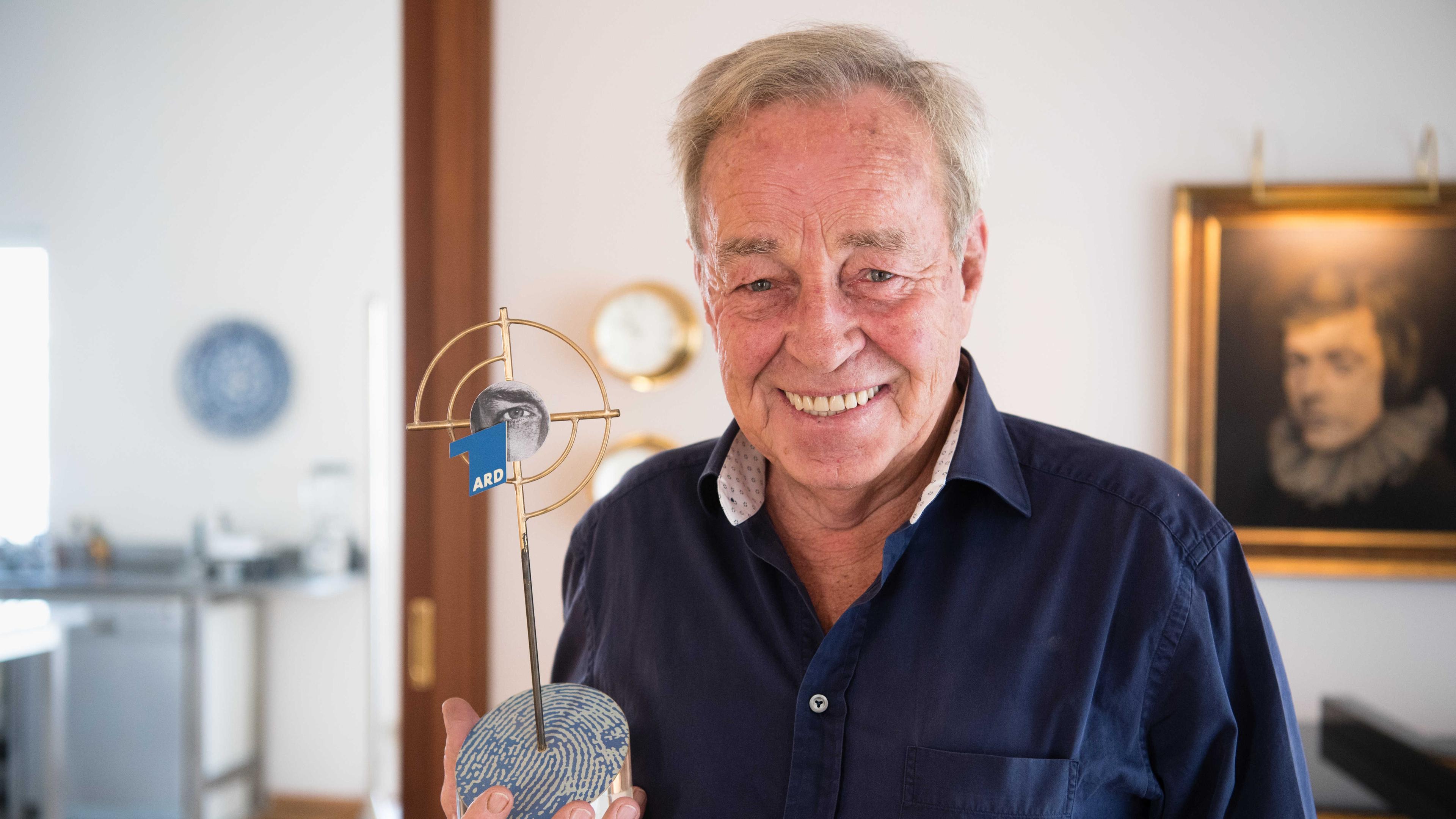 Horst Lettenmayer hält am 04.11.2016 in seiner Wohnung in Dachau eine Trophäe der Krimi-Reihe "Tatort", auf der sein eigenes Auge zu sehen ist, in der Hand.