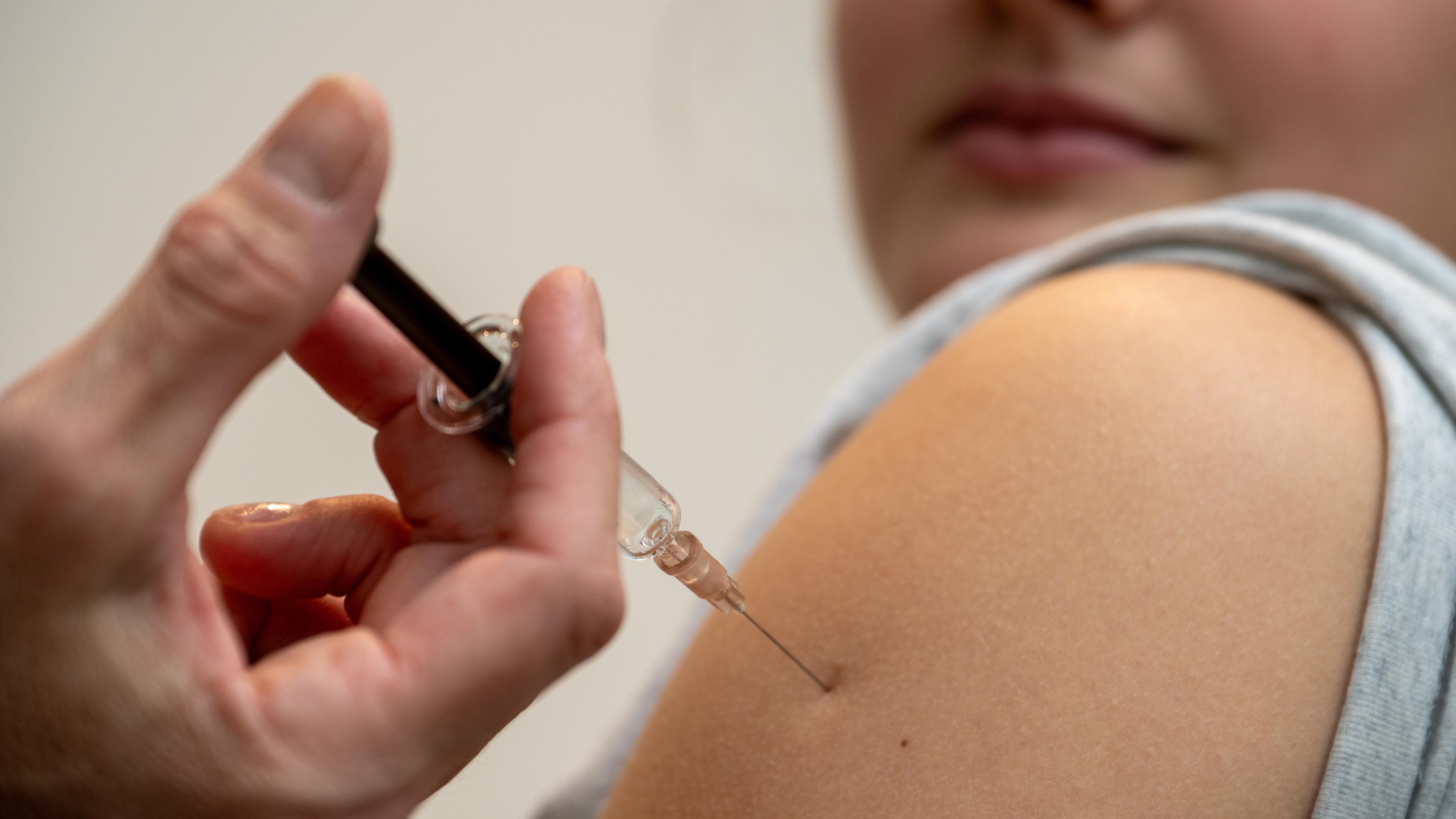 Nahaufnahme von einer Frau, die eine HPV-Impfung in den Oberarm erhält.